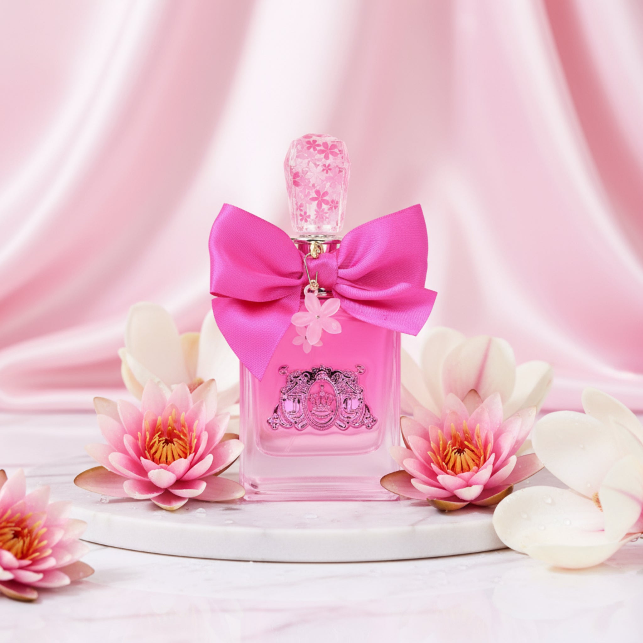 Viva La Juicy Petals Please by Juicy Couture perfume bottle on a pink background with water lilies