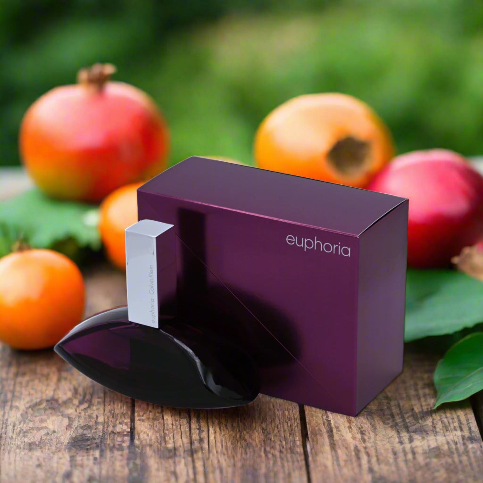Purple and black device with 'euphoria' branding on a wooden surface with pomegranates and apples in the background.
