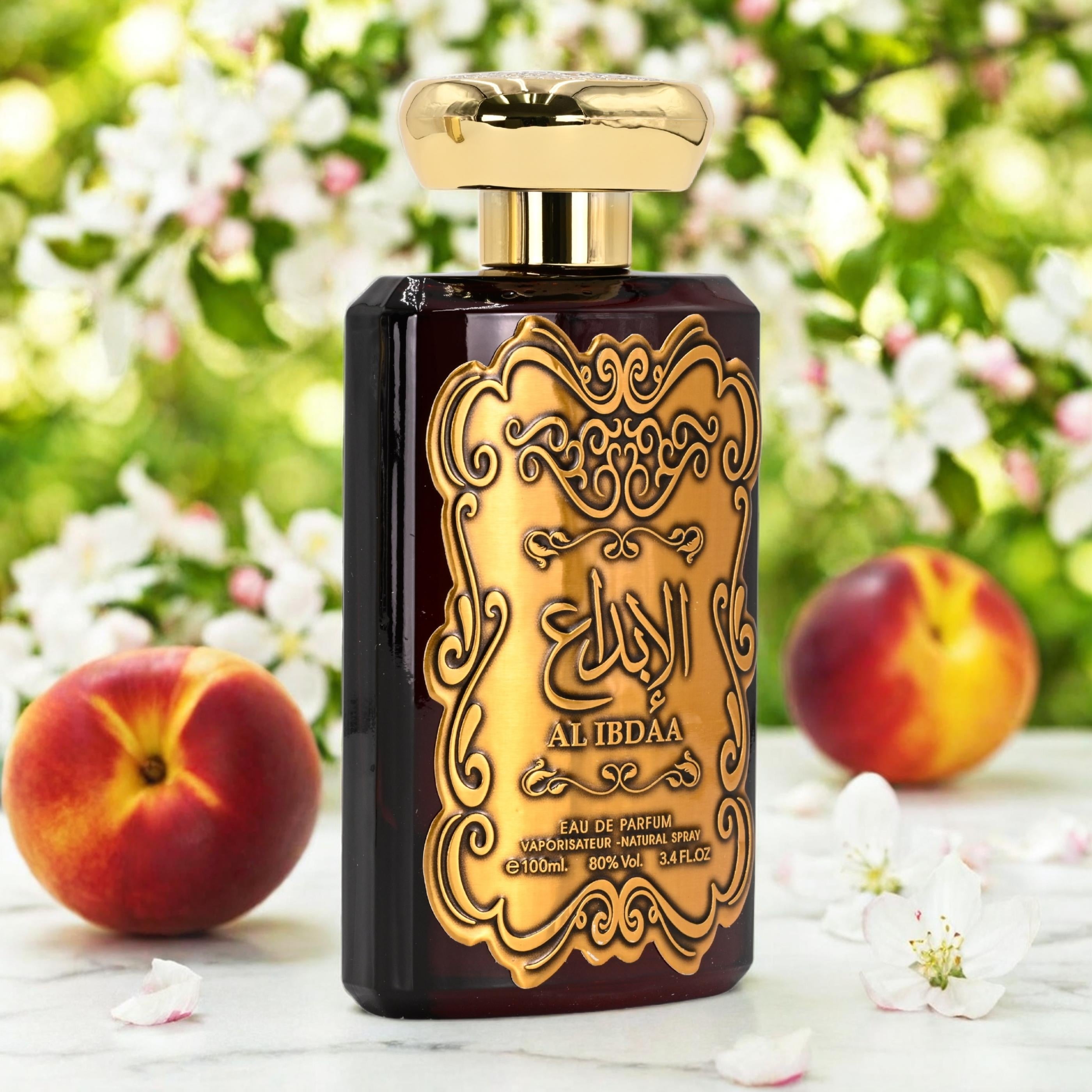 Perfume bottle with gold and black design in front of peaches and flowers