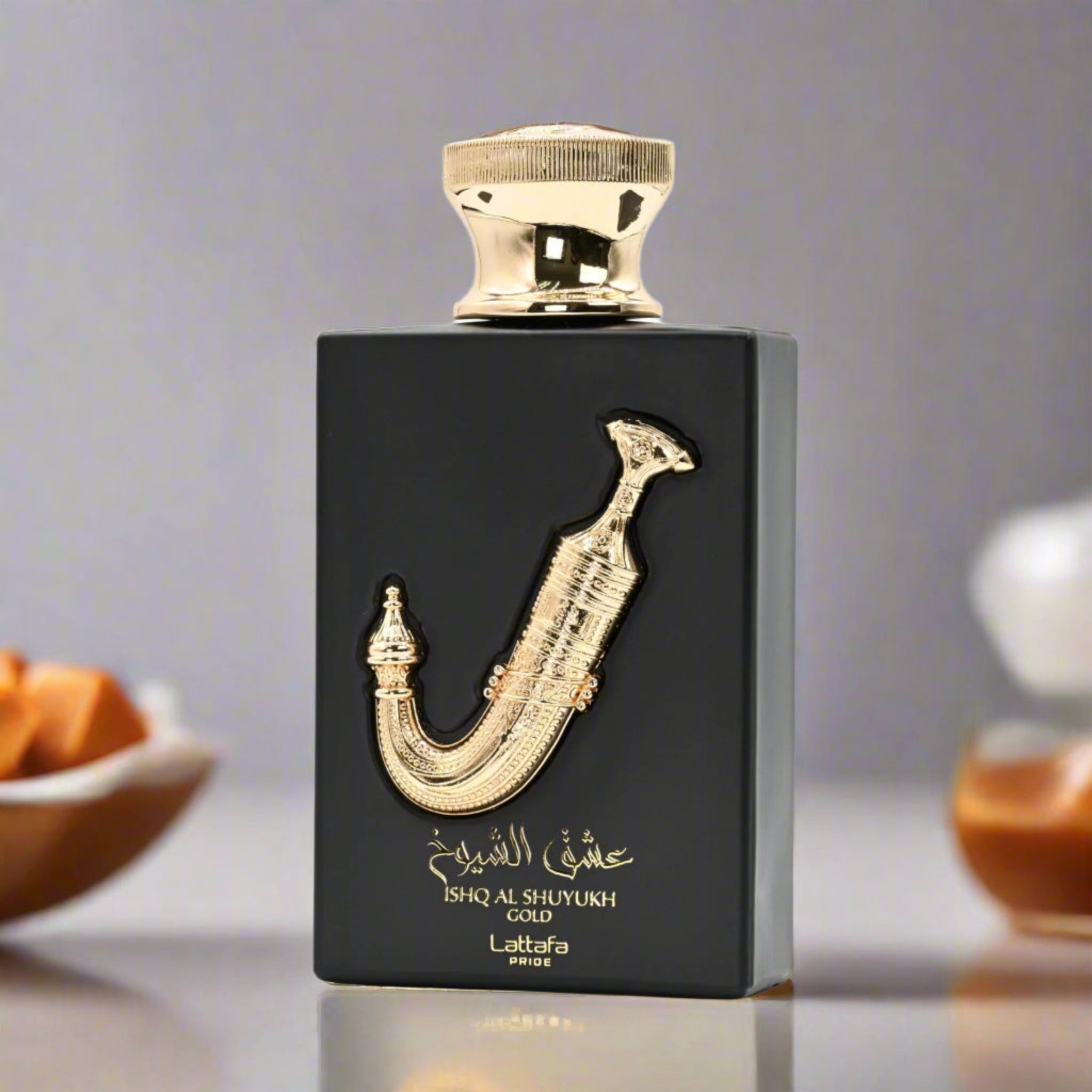 Black perfume bottle with gold accents on a reflective surface
