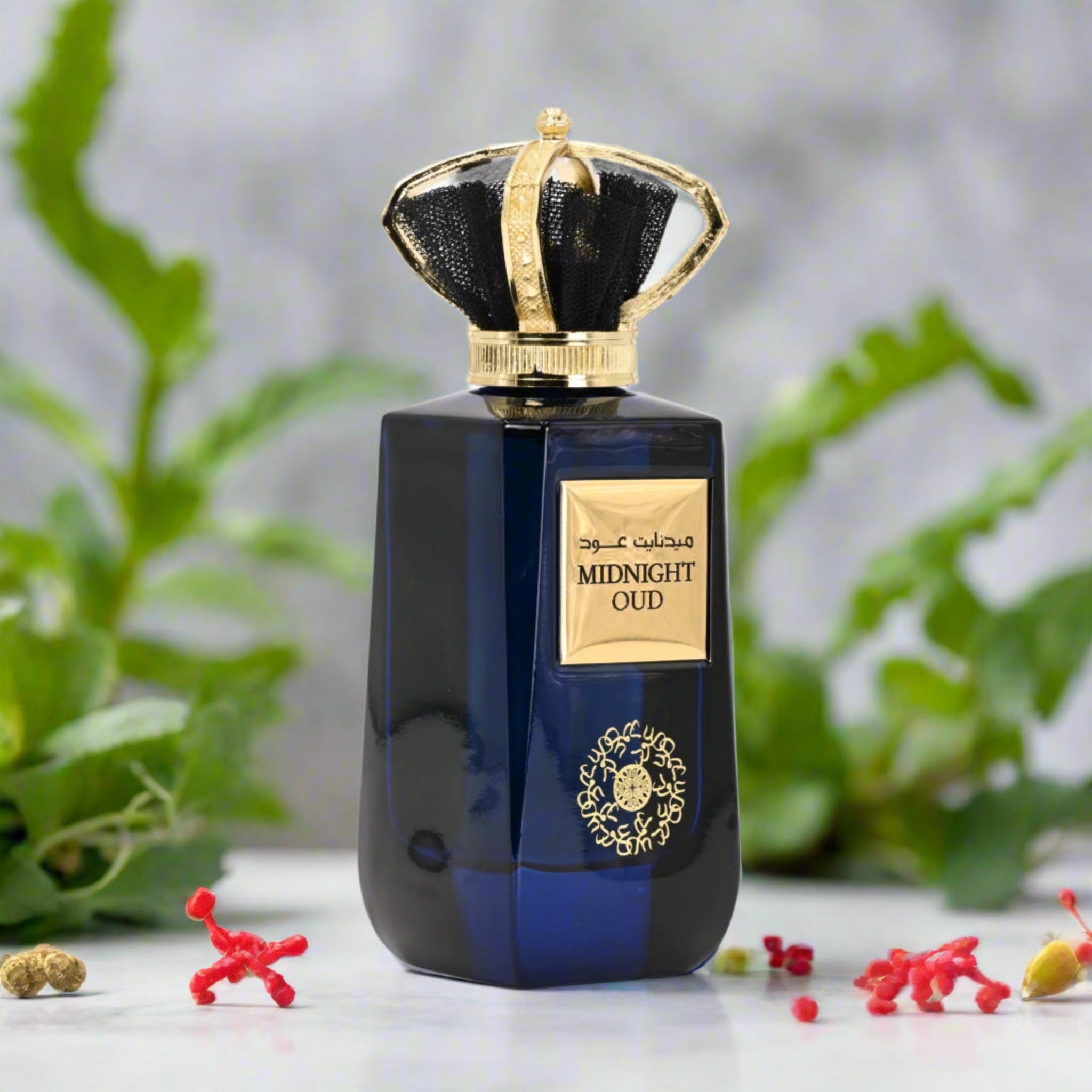 Blue perfume bottle with gold accents on a white surface with greenery in the background