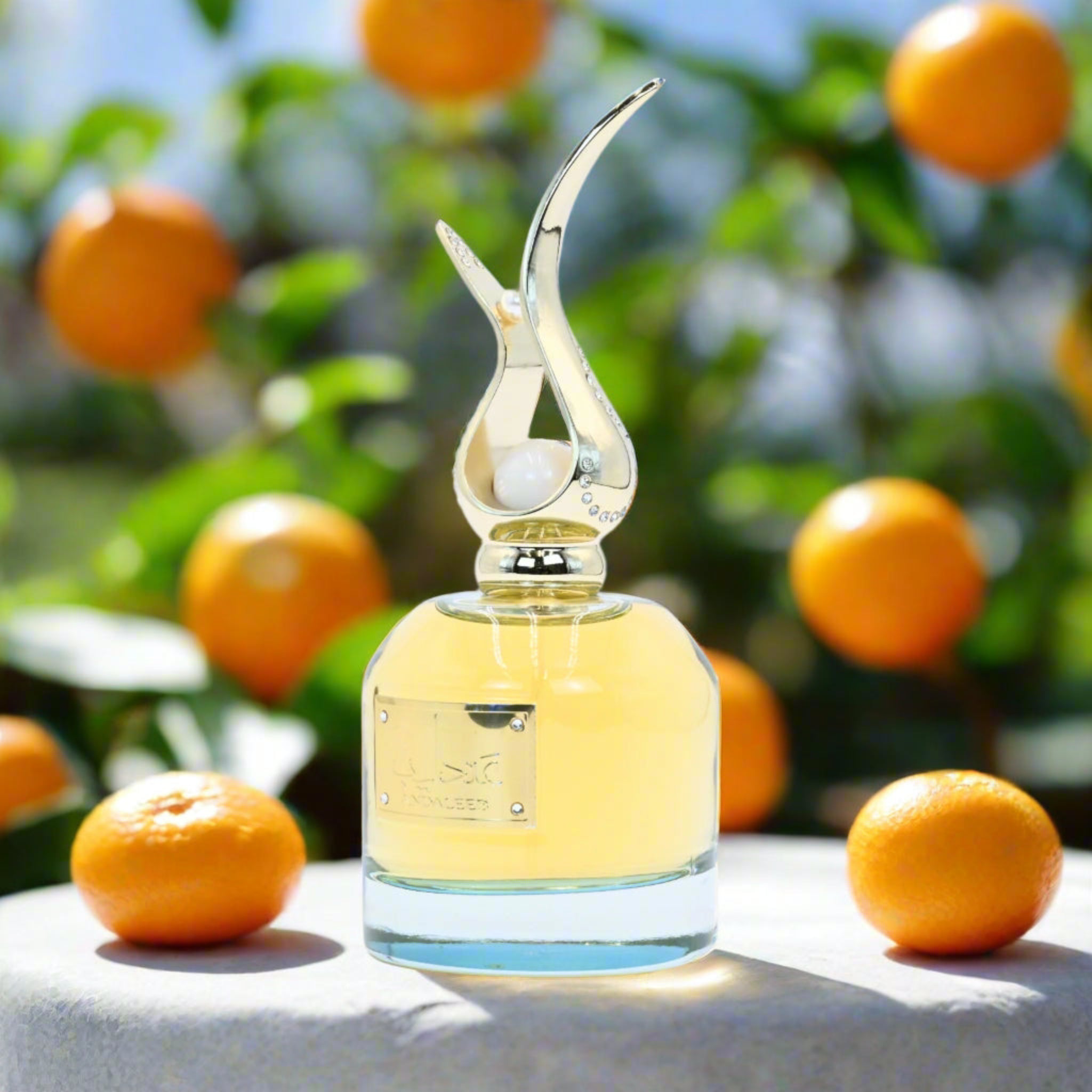 Perfume bottle with a decorative design on a surface with oranges in the background