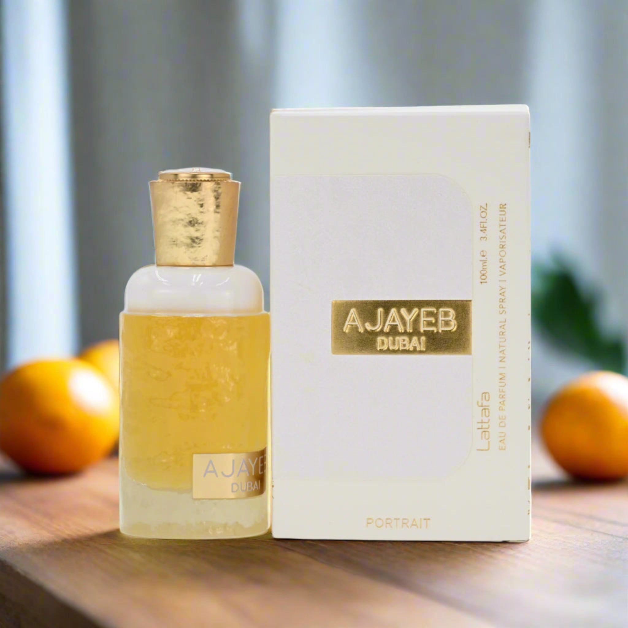 Perfume bottle and packaging with 'AJAYEB Dubai' branding on a wooden surface with fruits in the background.