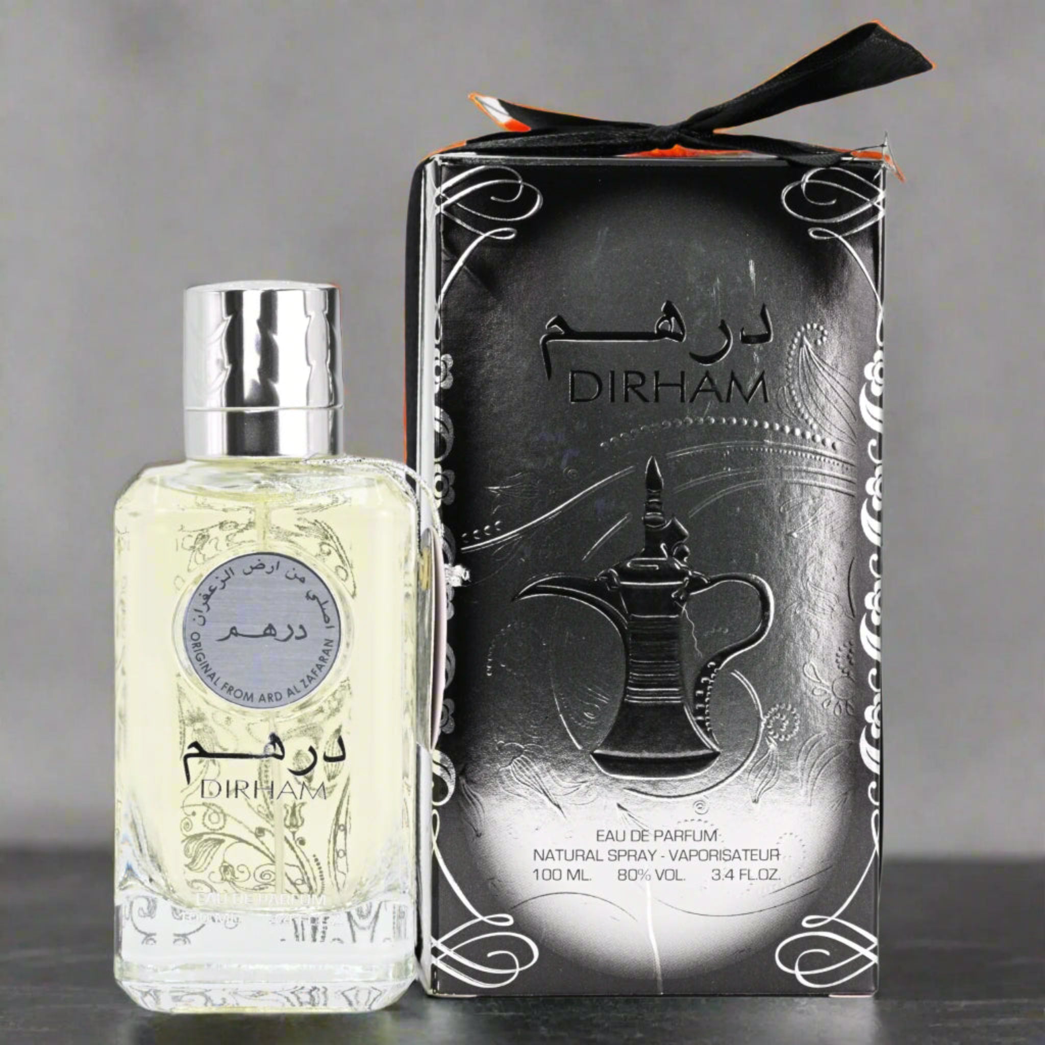 Perfume bottle and packaging with 'Dirham' branding on a gray background