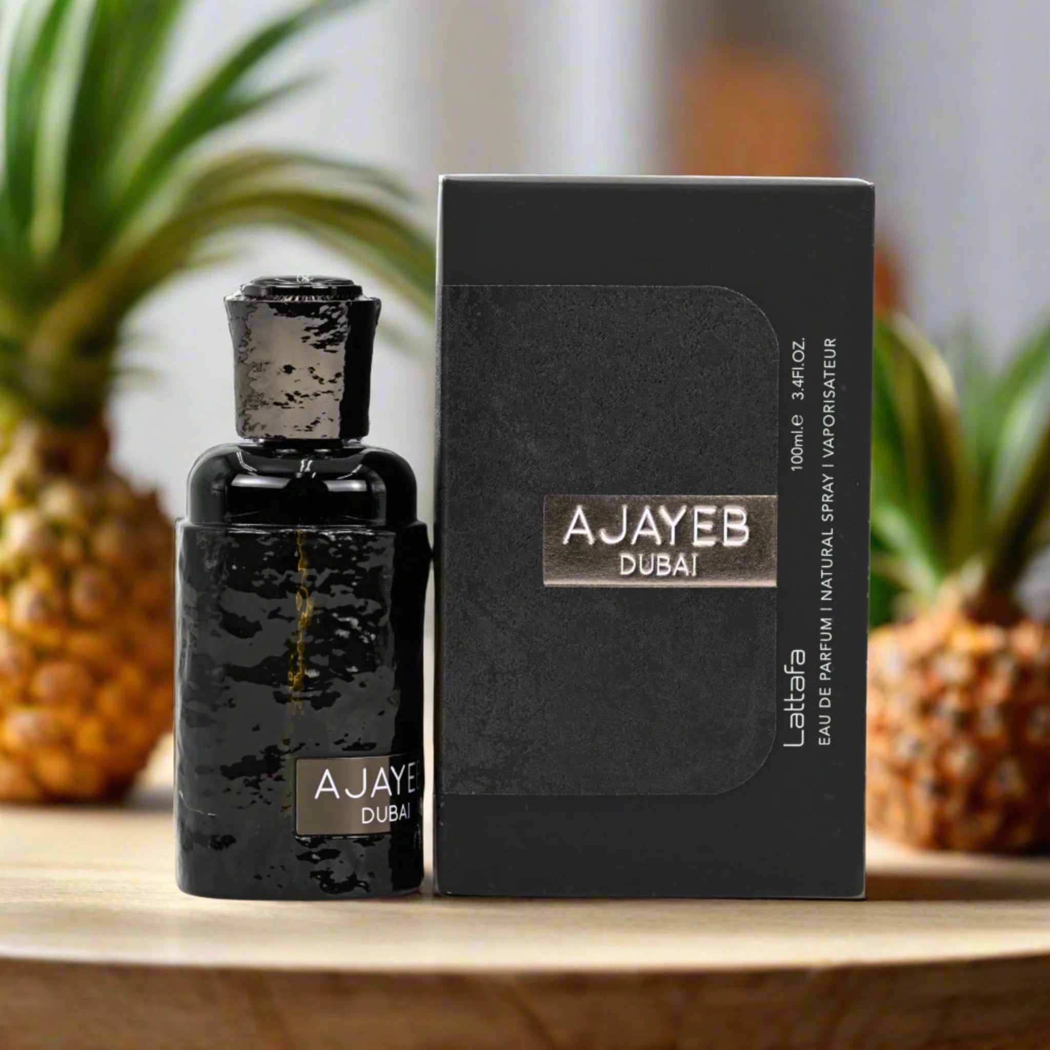 AJAYEB Dubai perfume bottle and packaging on a wooden surface with pineapples in the background
