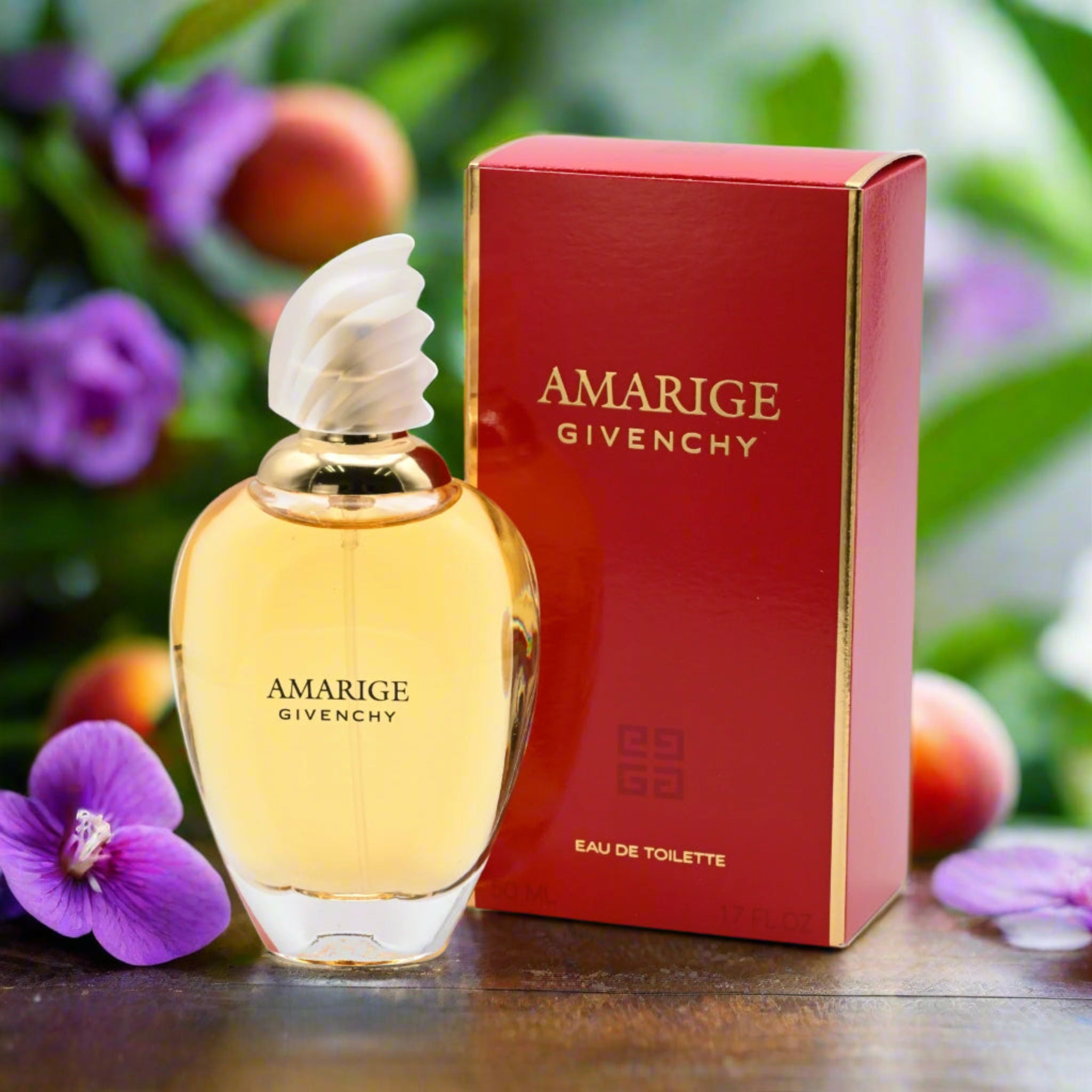 Givenchy Amarige perfume bottle and packaging with flowers in the background