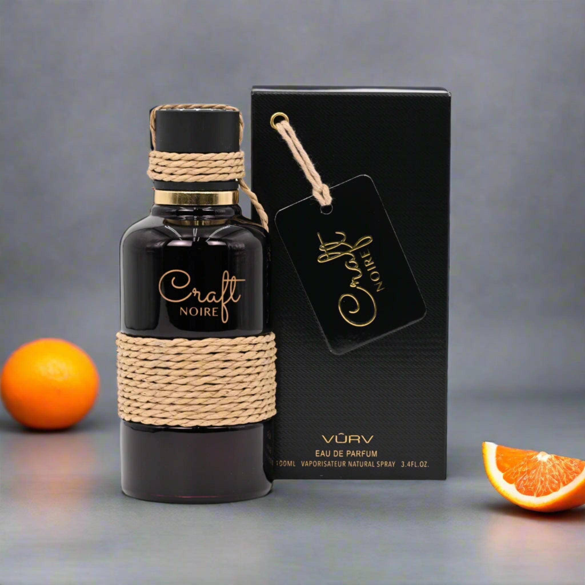 Black perfume bottle with woven design and matching box on a gray background