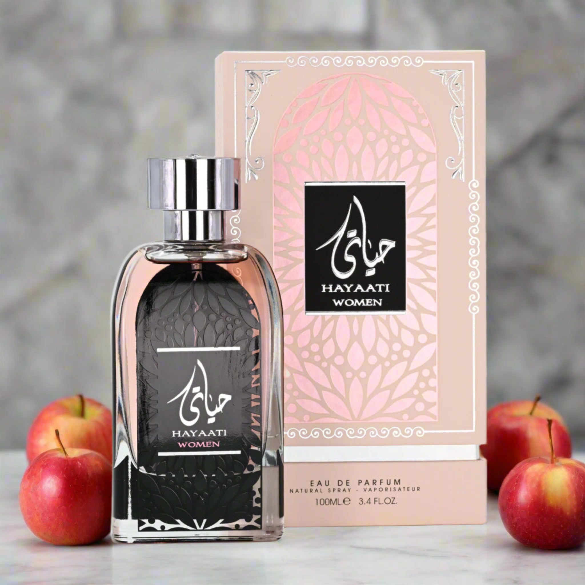 Hayaati Women perfume bottle and packaging with apples on a blurred background