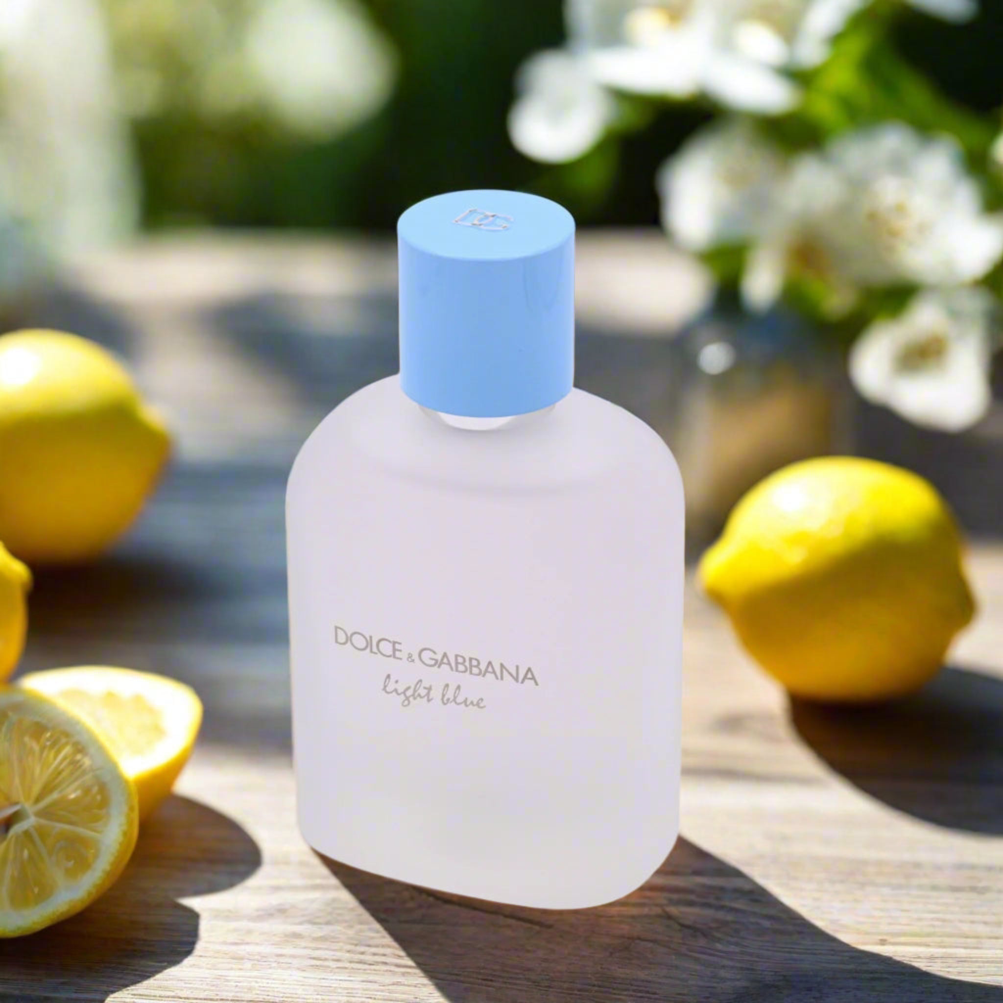 Dolce & Gabbana light blue perfume bottle with lemons on a wooden surface
