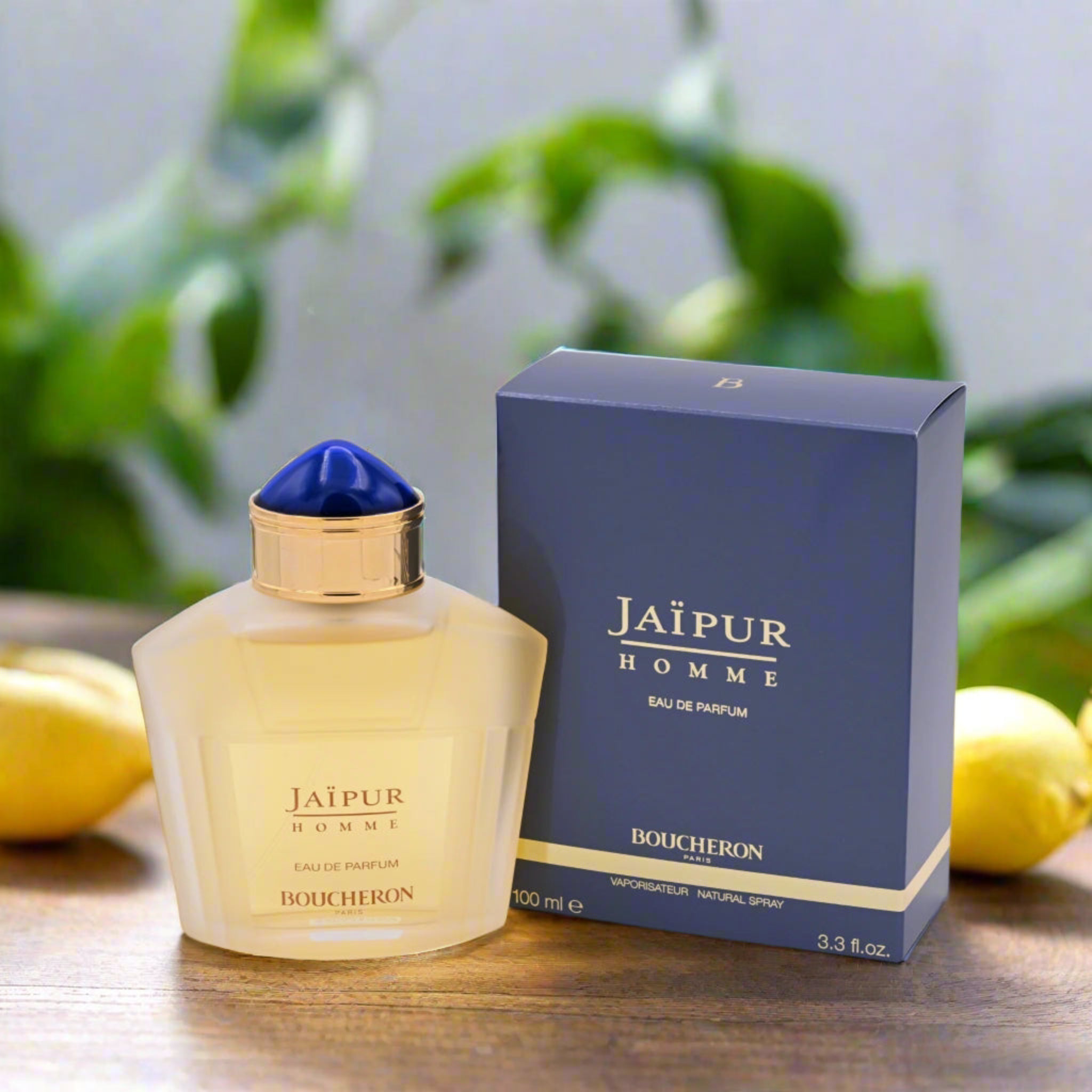 Boucheron Jaipur Homme perfume bottle and packaging on a wooden surface with greenery in the background