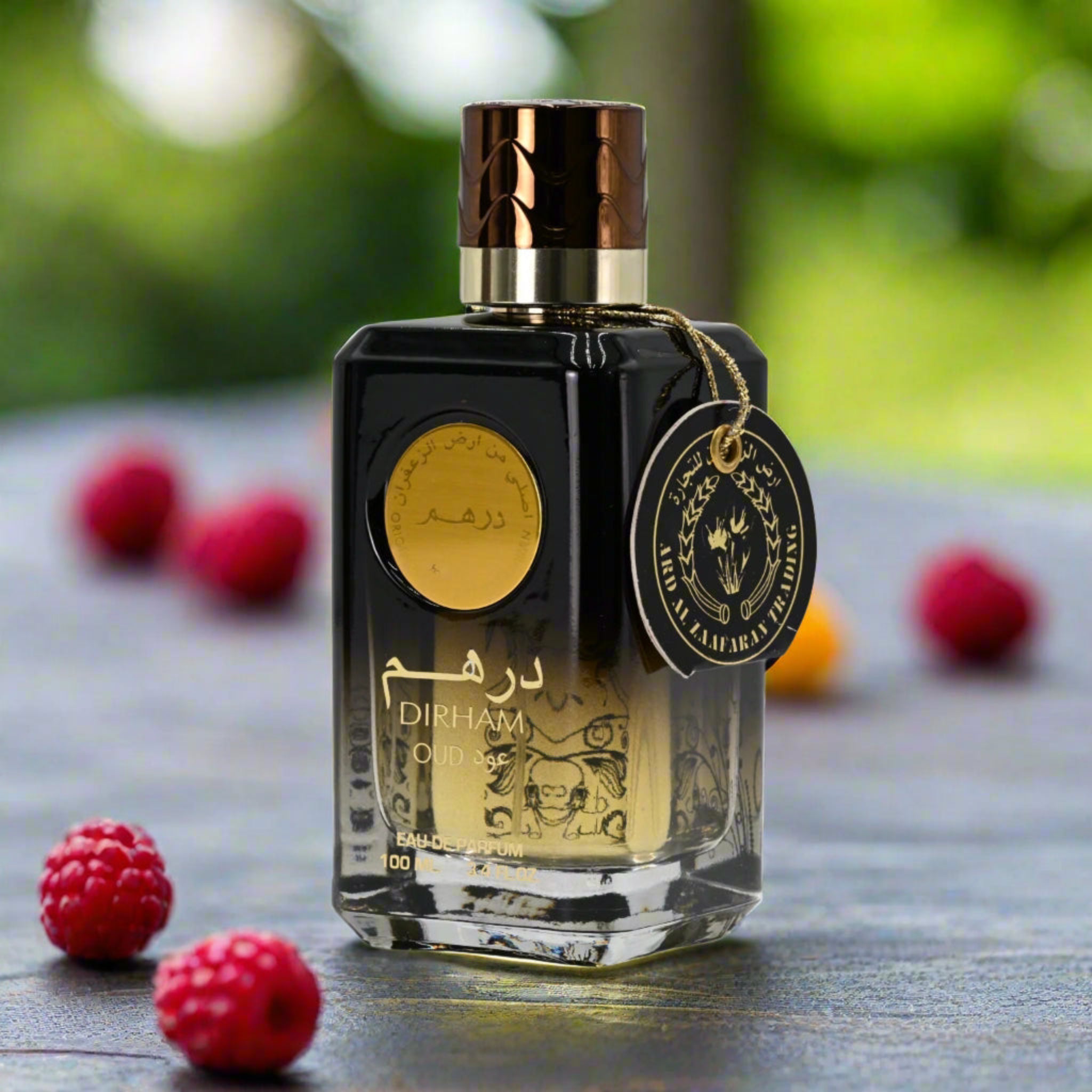 Perfume bottle with a gold cap and label on a wooden surface with raspberries.