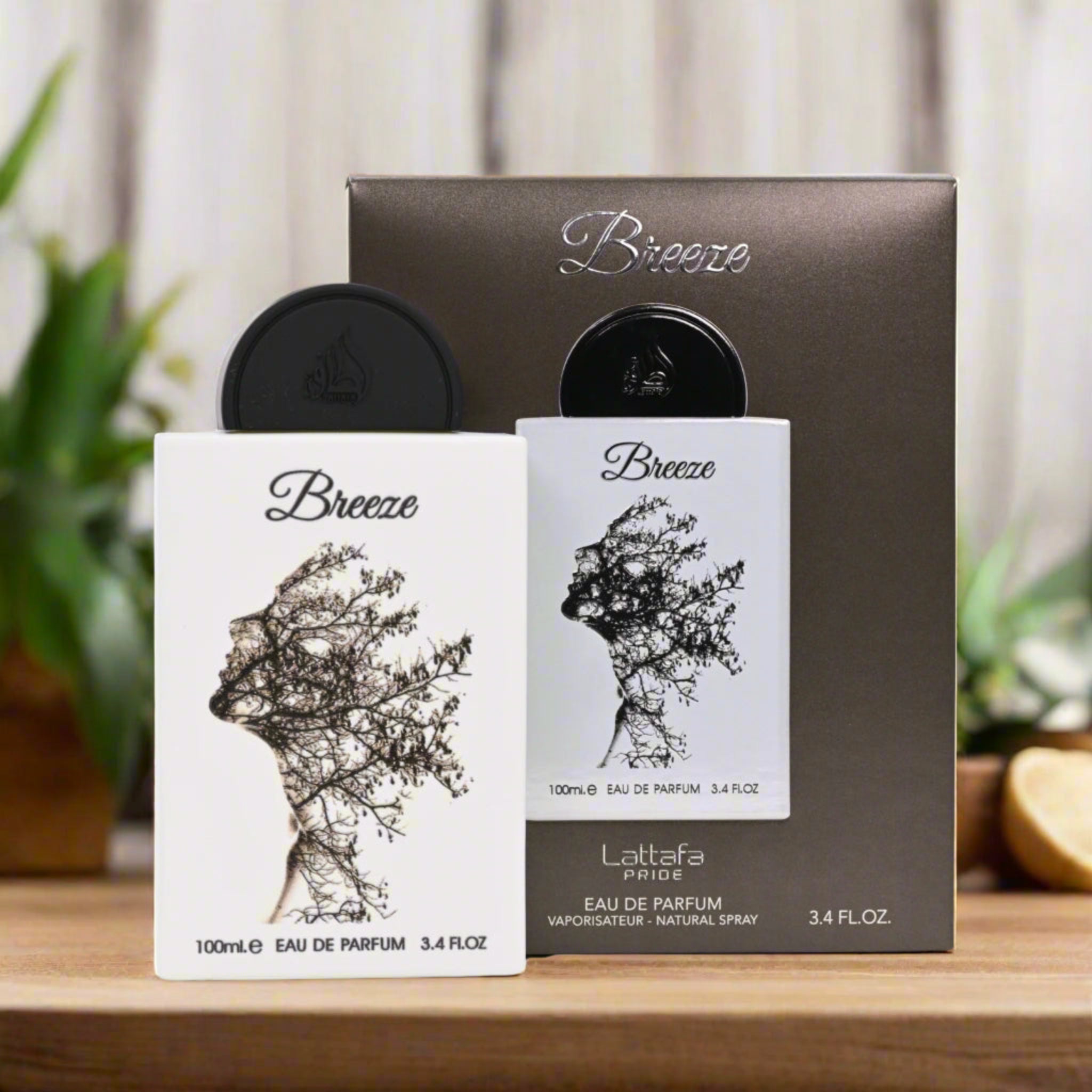 Two Lattafa 'Breeze' perfume bottles with packaging on a wooden surface.