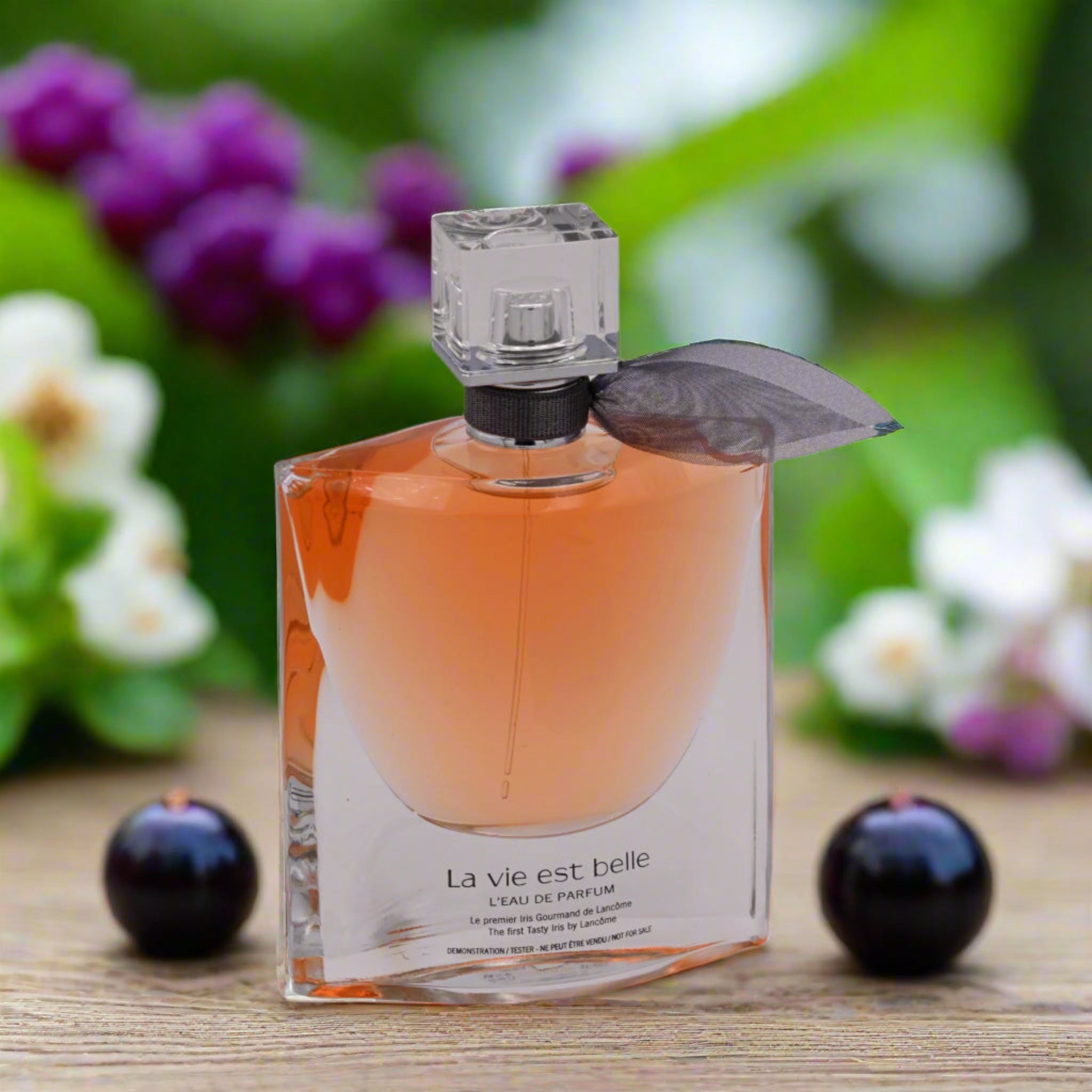 Perfume bottle labeled 'La vie est belle' with a blurred floral background