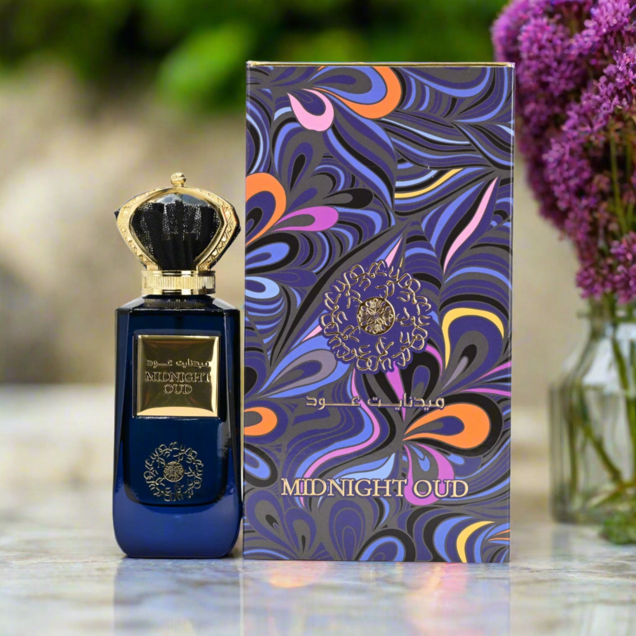 Blue perfume bottle with gold accents and colorful packaging labeled 'Midnight Oud' on a reflective surface.