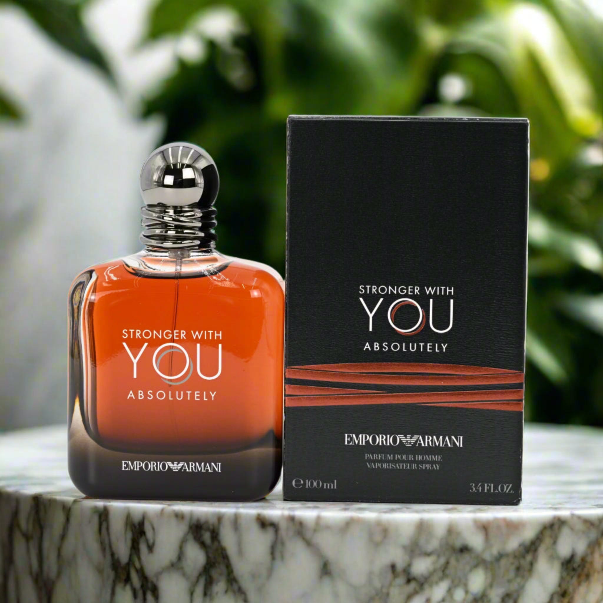 Emporio Armani perfume bottle and packaging on a marble surface with greenery in the background
