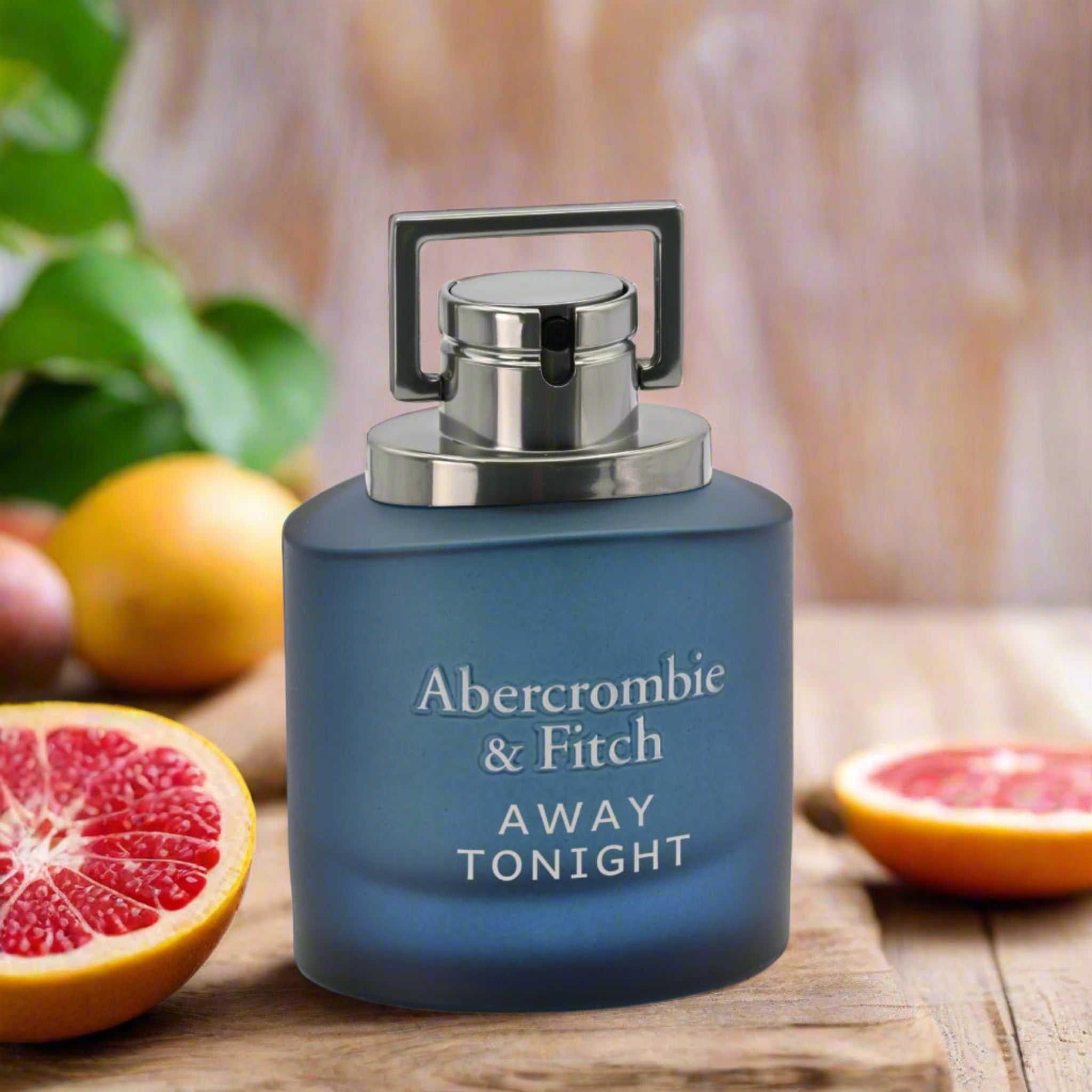 Blue Abercrombie & Fitch perfume bottle with fruits on a wooden surface