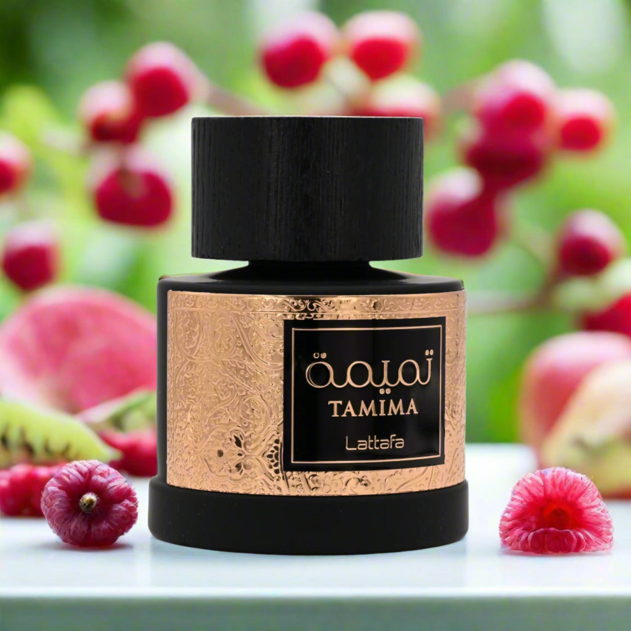 Perfume bottle with 'Tamima' label on a table with fruits and flowers in the background