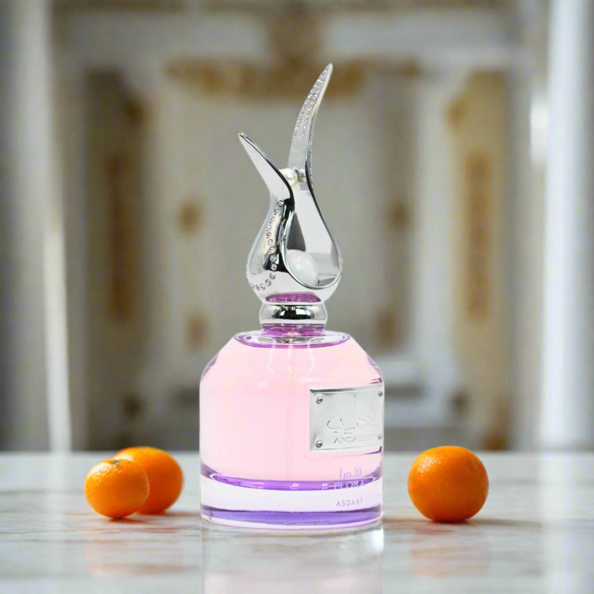 Decorative bottle with a unique design on a reflective surface with oranges.