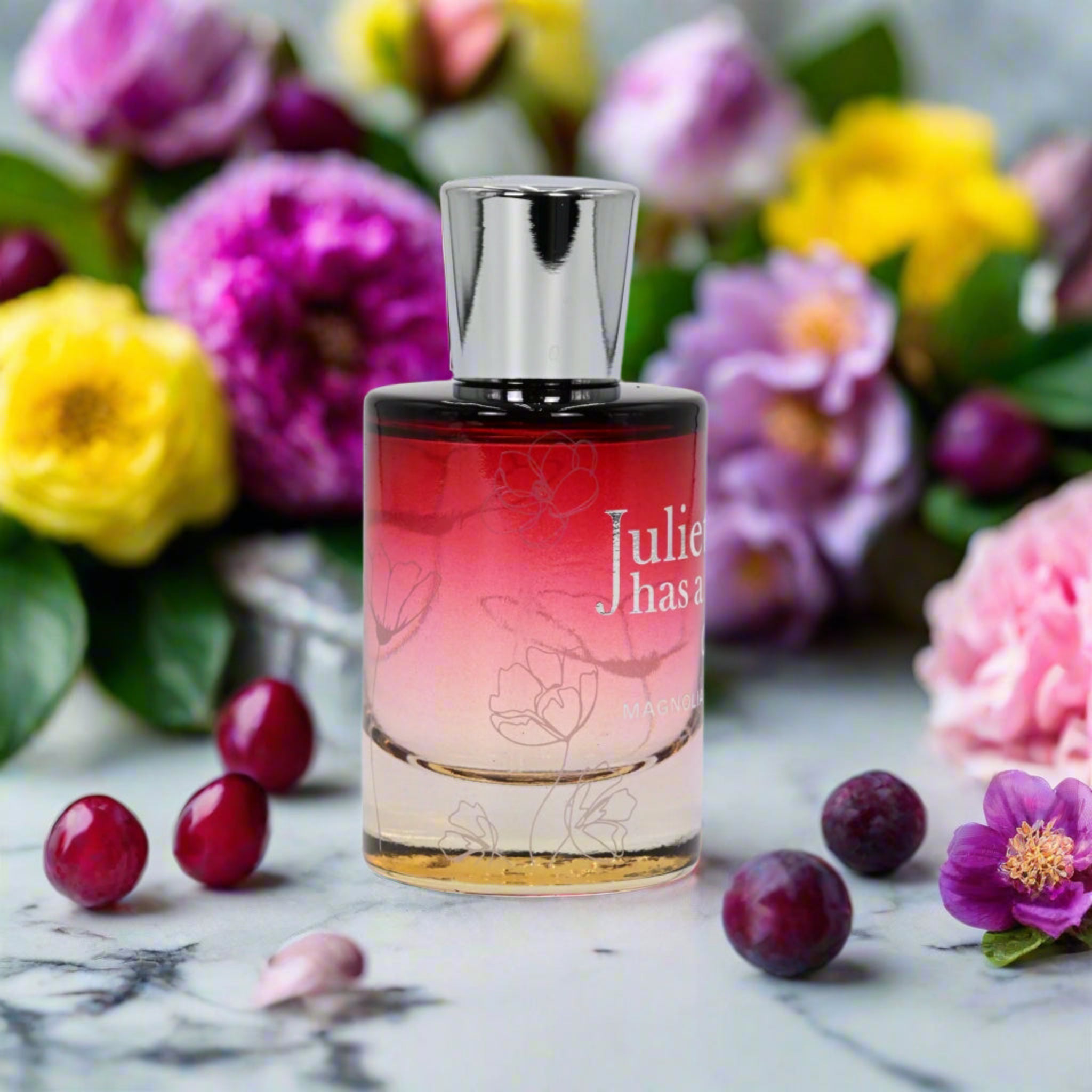 Perfume bottle with colorful flowers and berries in the background