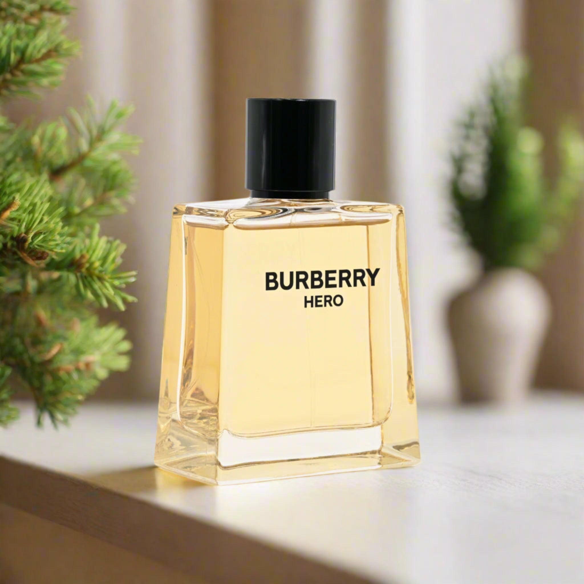 Burberry Hero perfume bottle on a neutral background with plants.