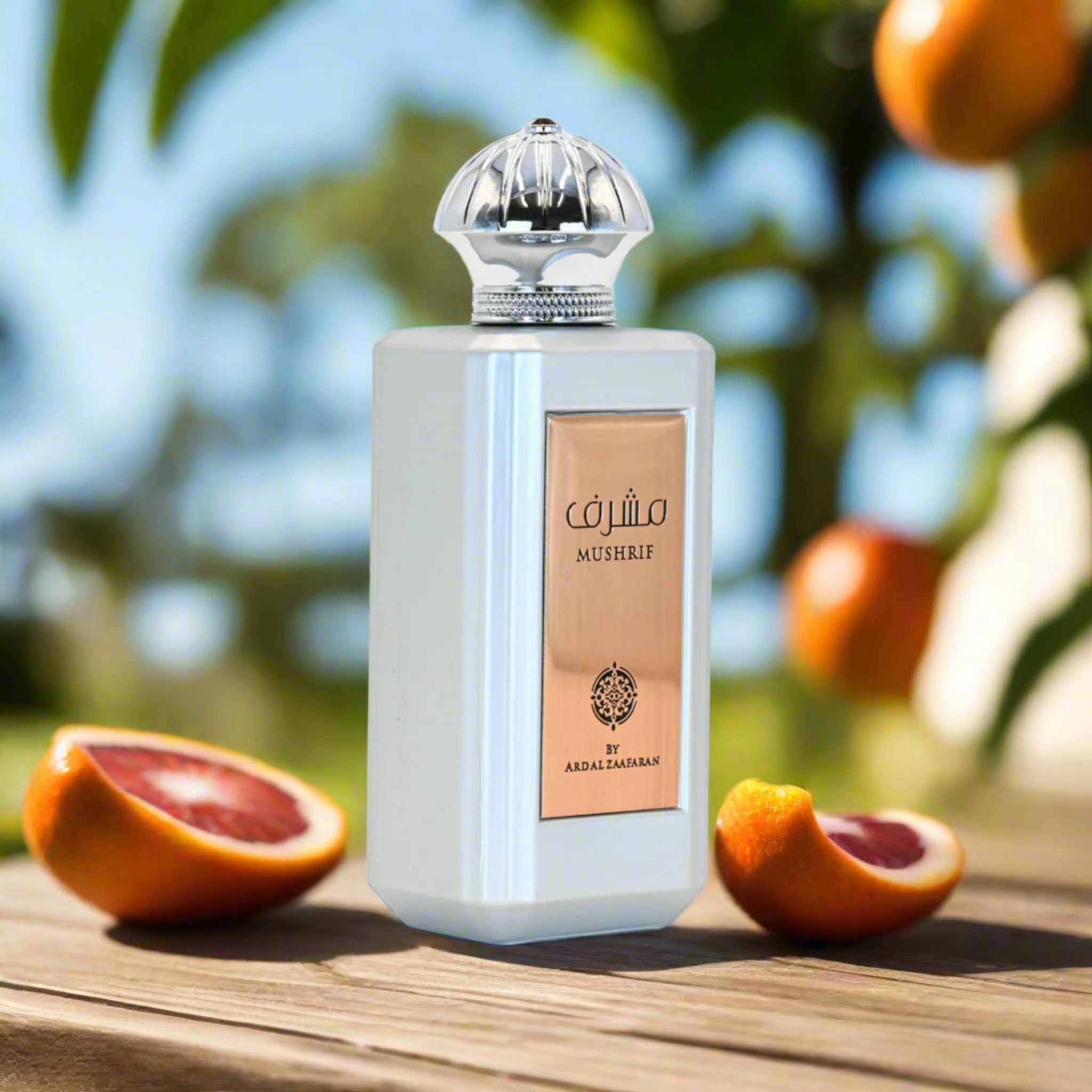 Perfume bottle labeled 'Mushrif' with blood oranges on a wooden surface