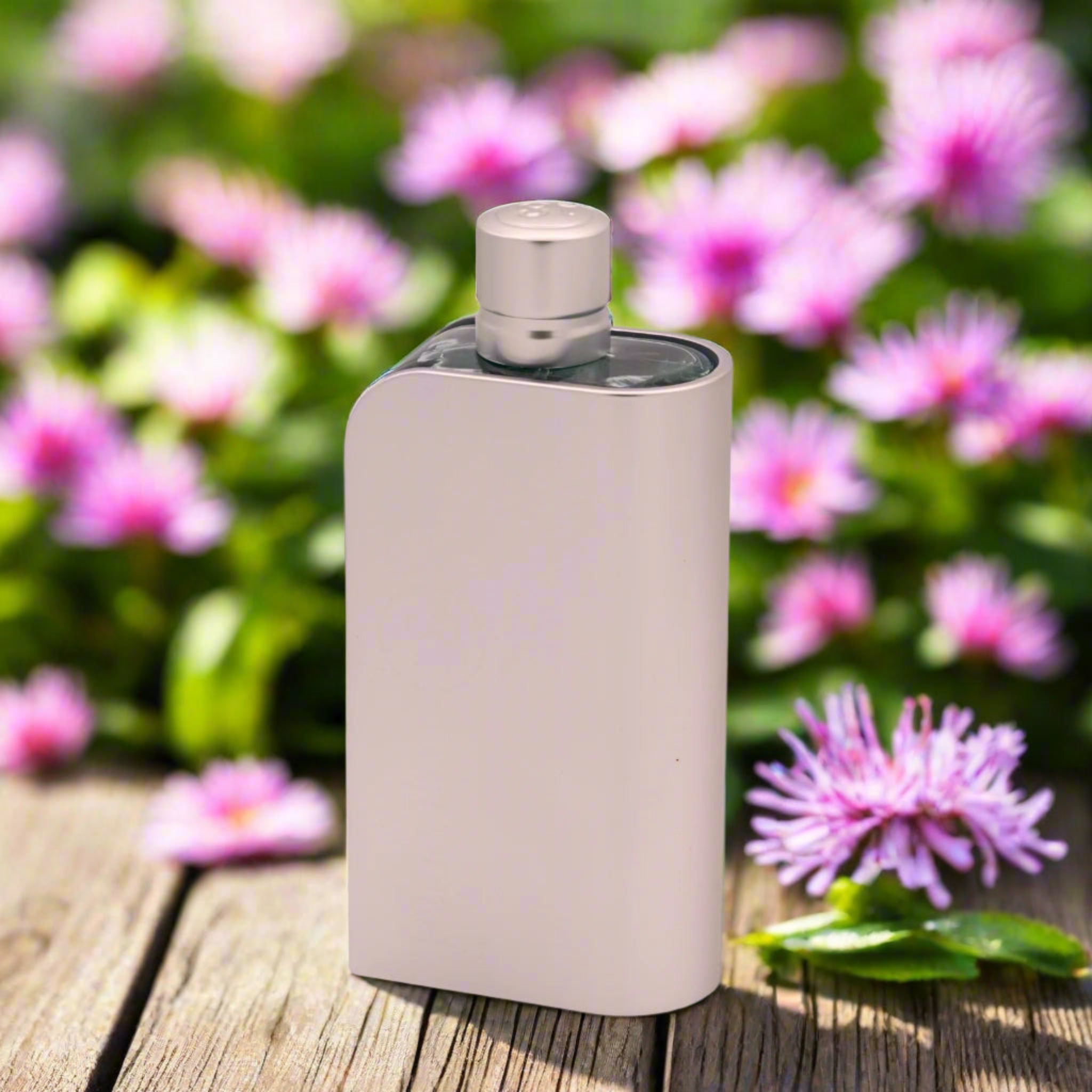 Beige electronic device on a wooden surface with pink flowers in the background