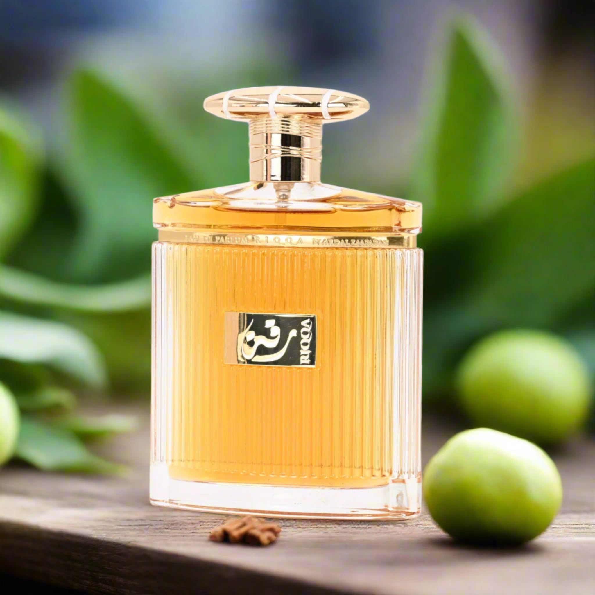 Perfume bottle with gold cap on a wooden surface with green leaves in the background