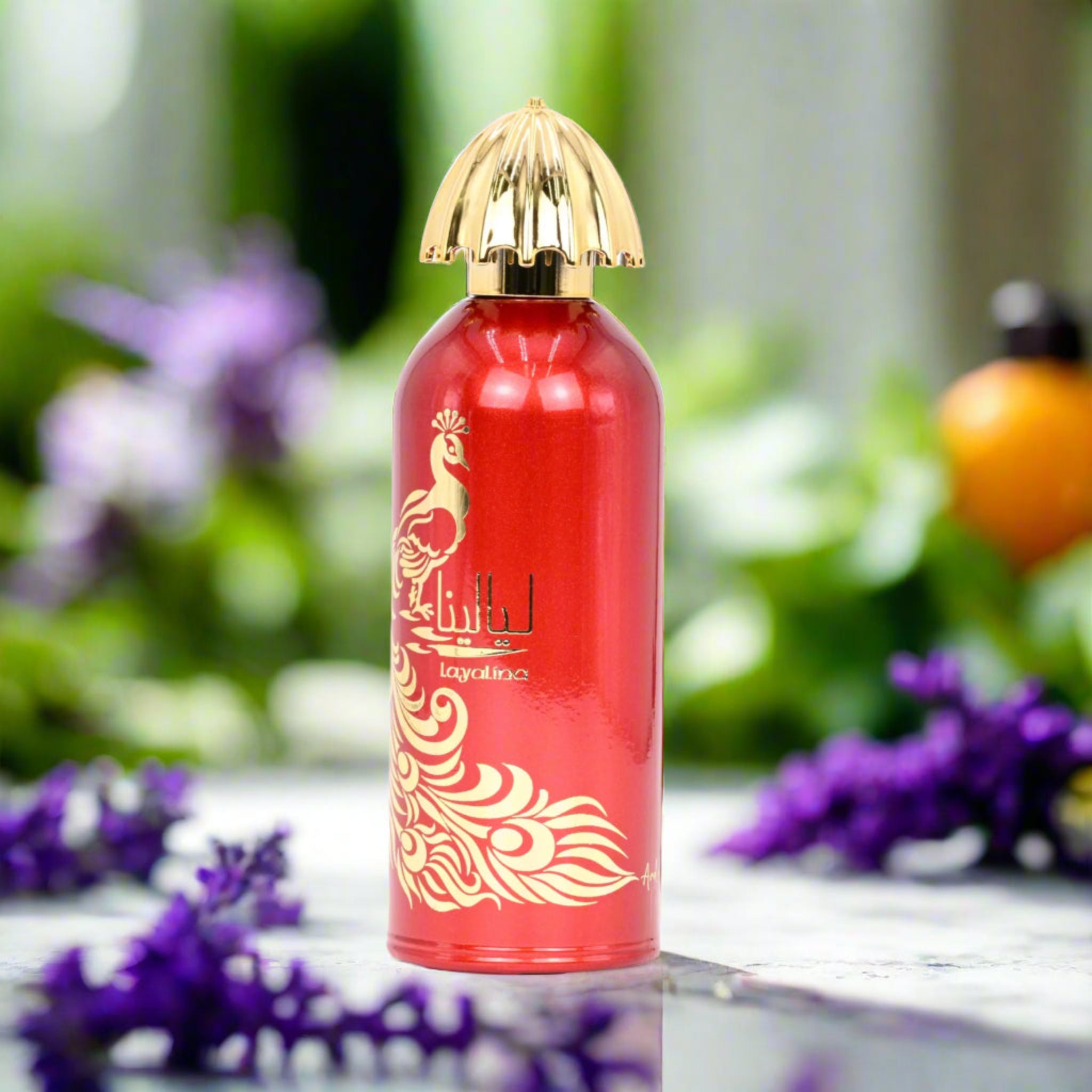 Red perfume bottle with gold cap on a table with flowers in the background