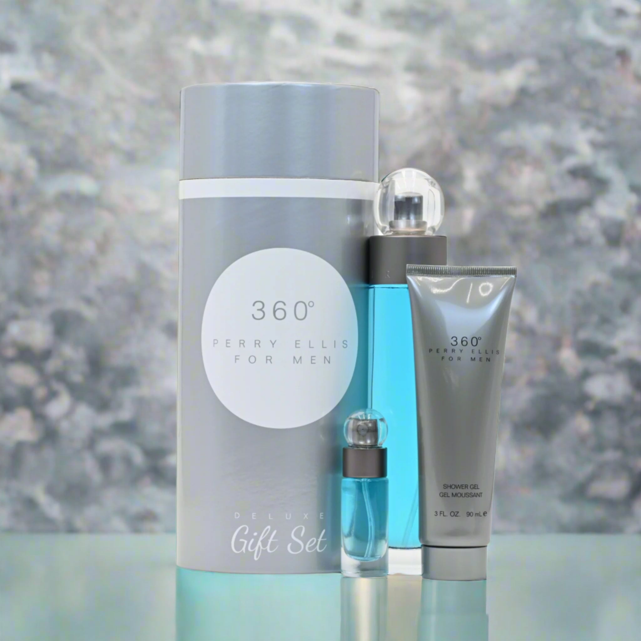 Perry Ellis 360° men's grooming gift set with cylindrical container, bottle, and tube on a reflective surface.