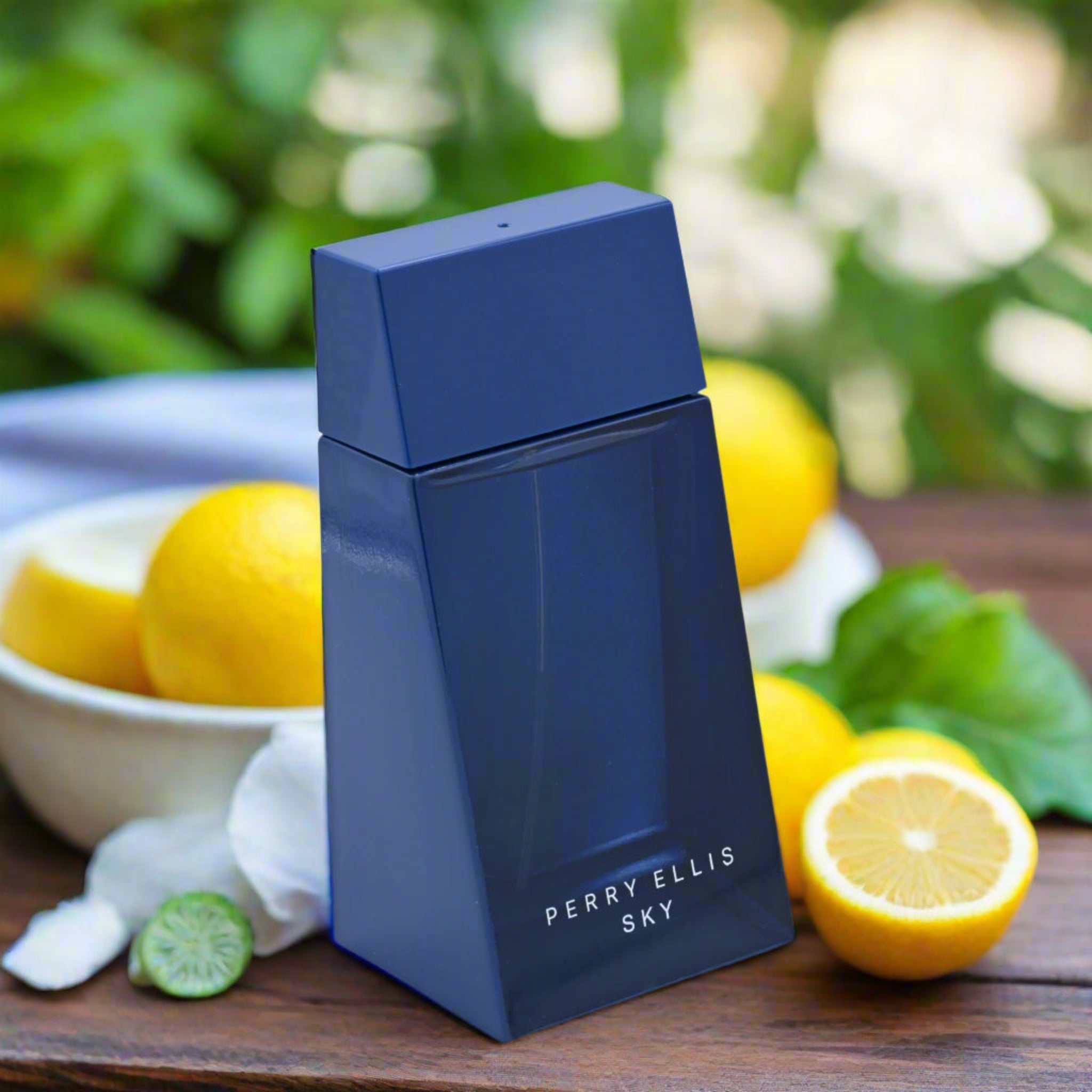 Blue Perry Ellis Sky perfume bottle with lemons and greenery in the background