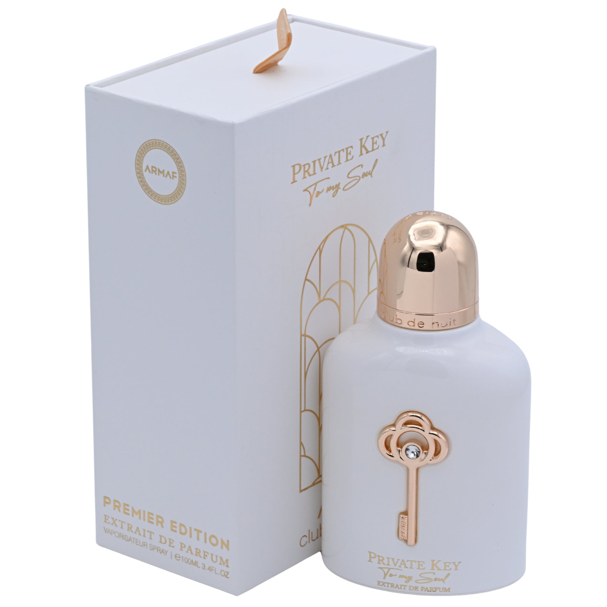 Perfume bottle with gold cap and key design next to its packaging on a white background