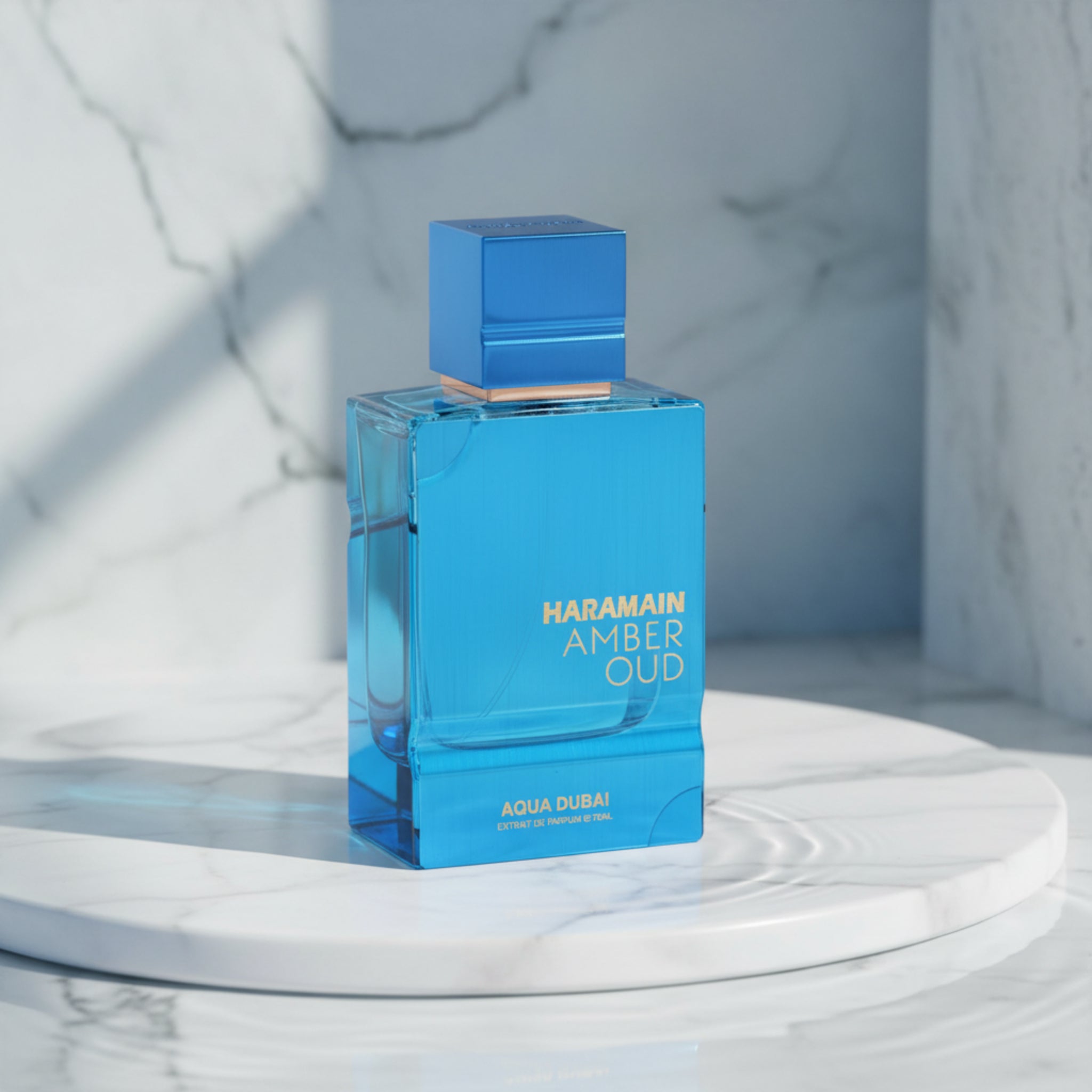 Blue perfume bottle labeled 'Haramain Amber Oud Aqua Dubai' on a white background