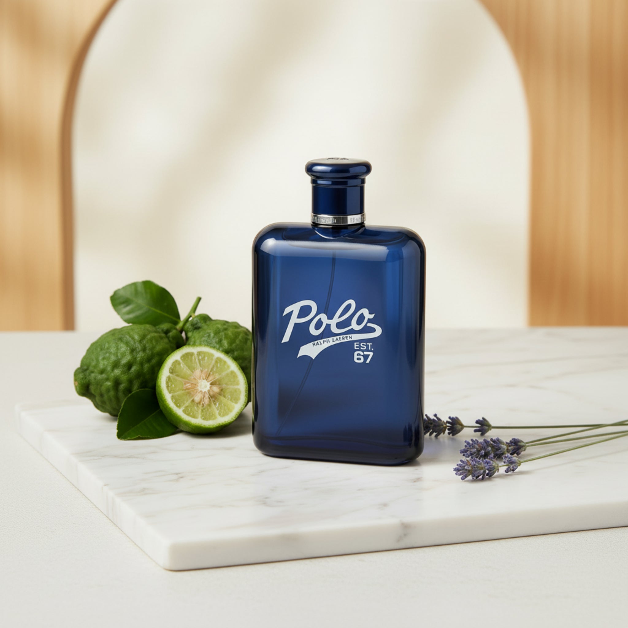 Blue Polo perfume bottle on a marble surface with green fruit and lavender.