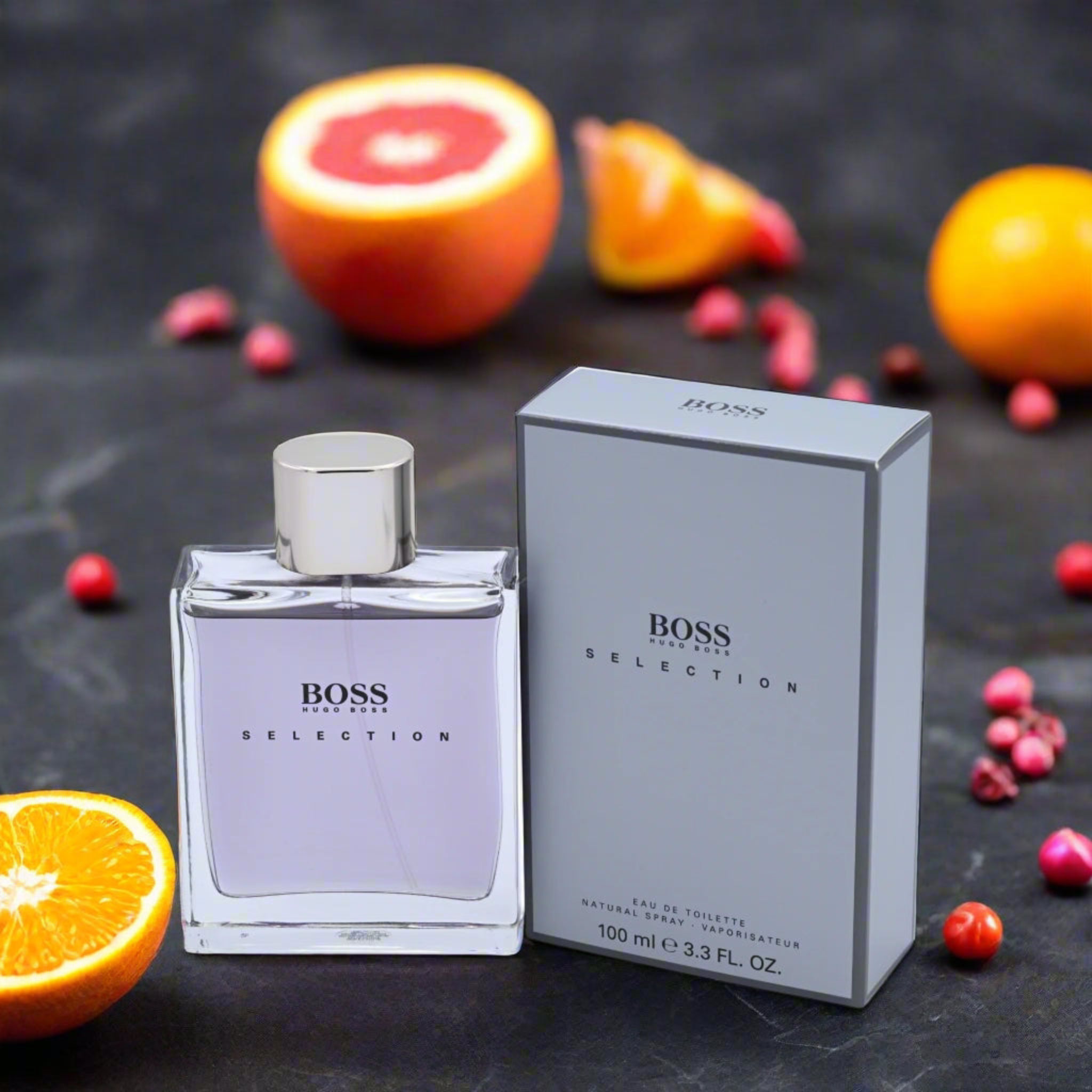 BOSS Selection perfume bottle and packaging with fruits on a dark background