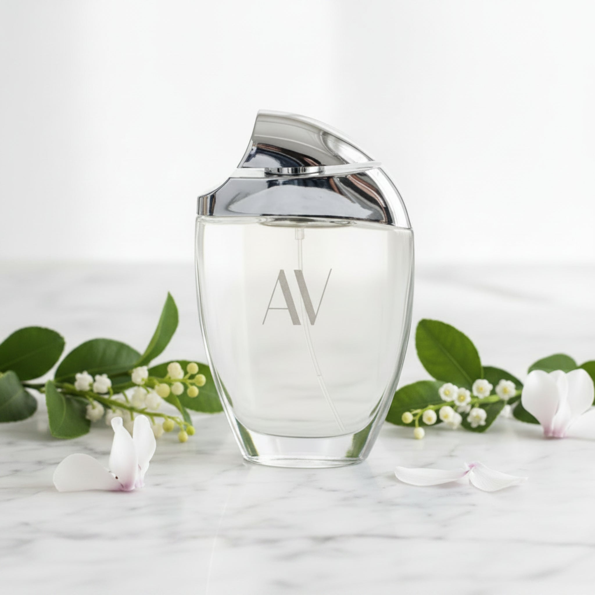 Clear perfume bottle with silver cap on a white background