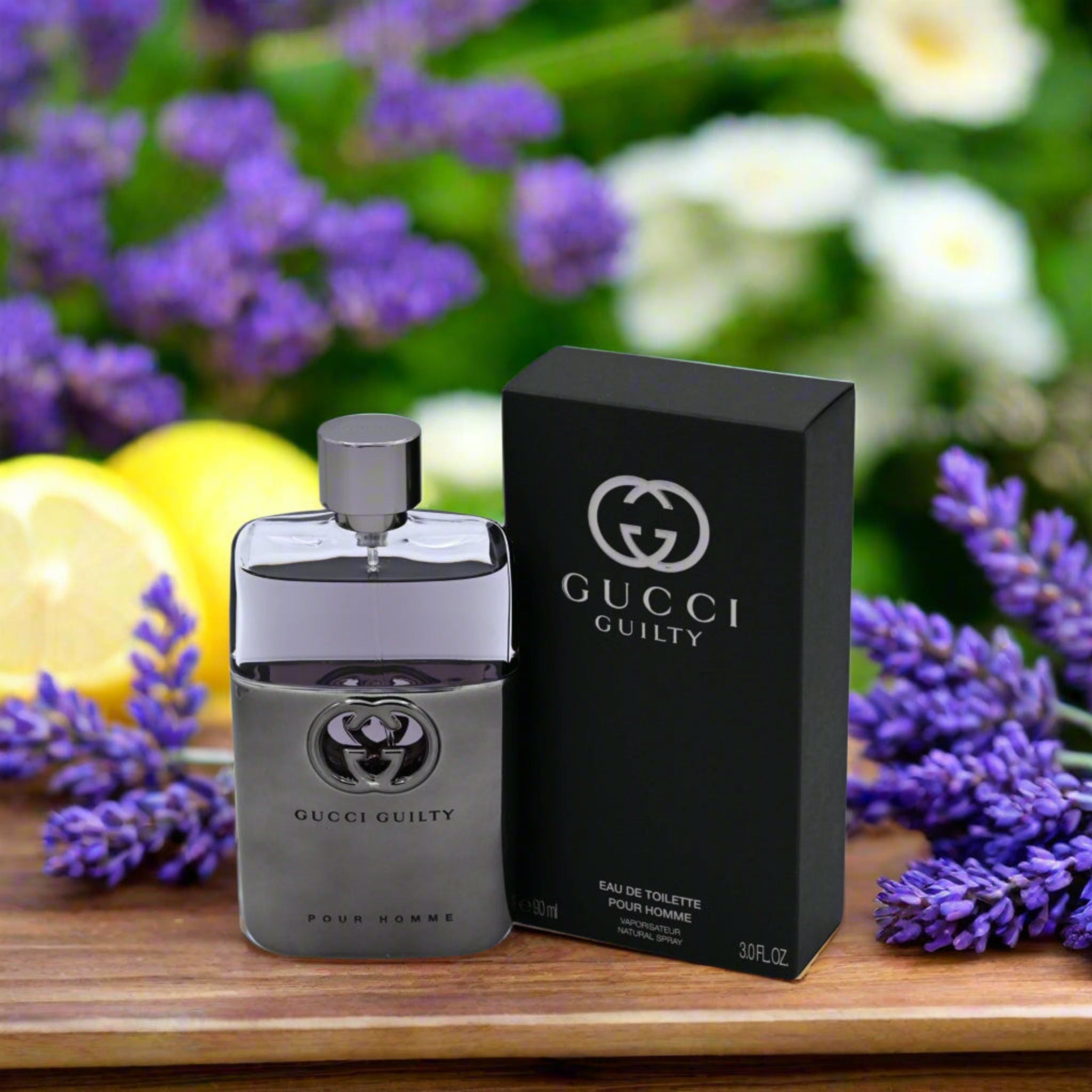 Gucci Guilty perfume bottle and packaging on a wooden surface with flowers in the background
