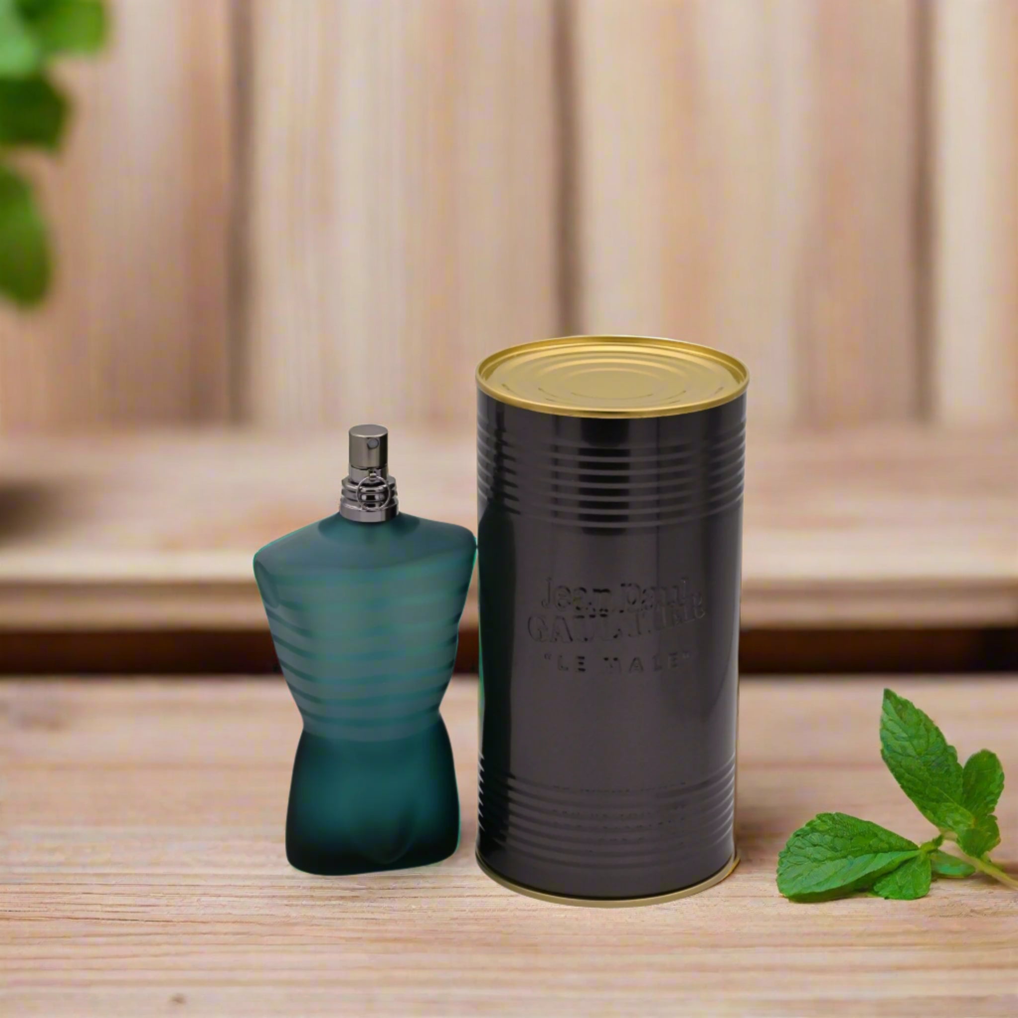 Green perfume bottle and cylindrical black container with gold lid on a white background
