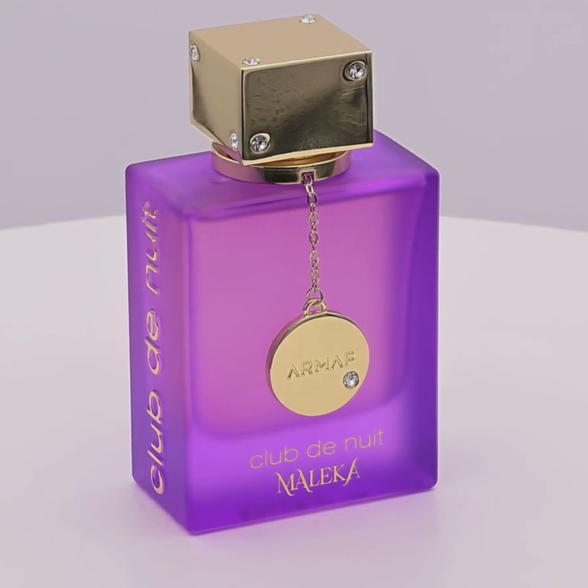 Purple perfume bottle rotating on a white podium