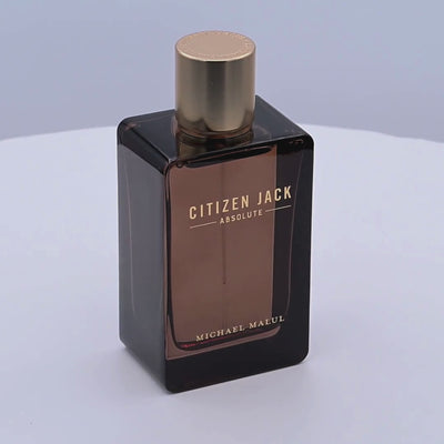 Perfume bottle labeled 'Citizen Jack Absolute' by Michael Malul rotating on a white podium