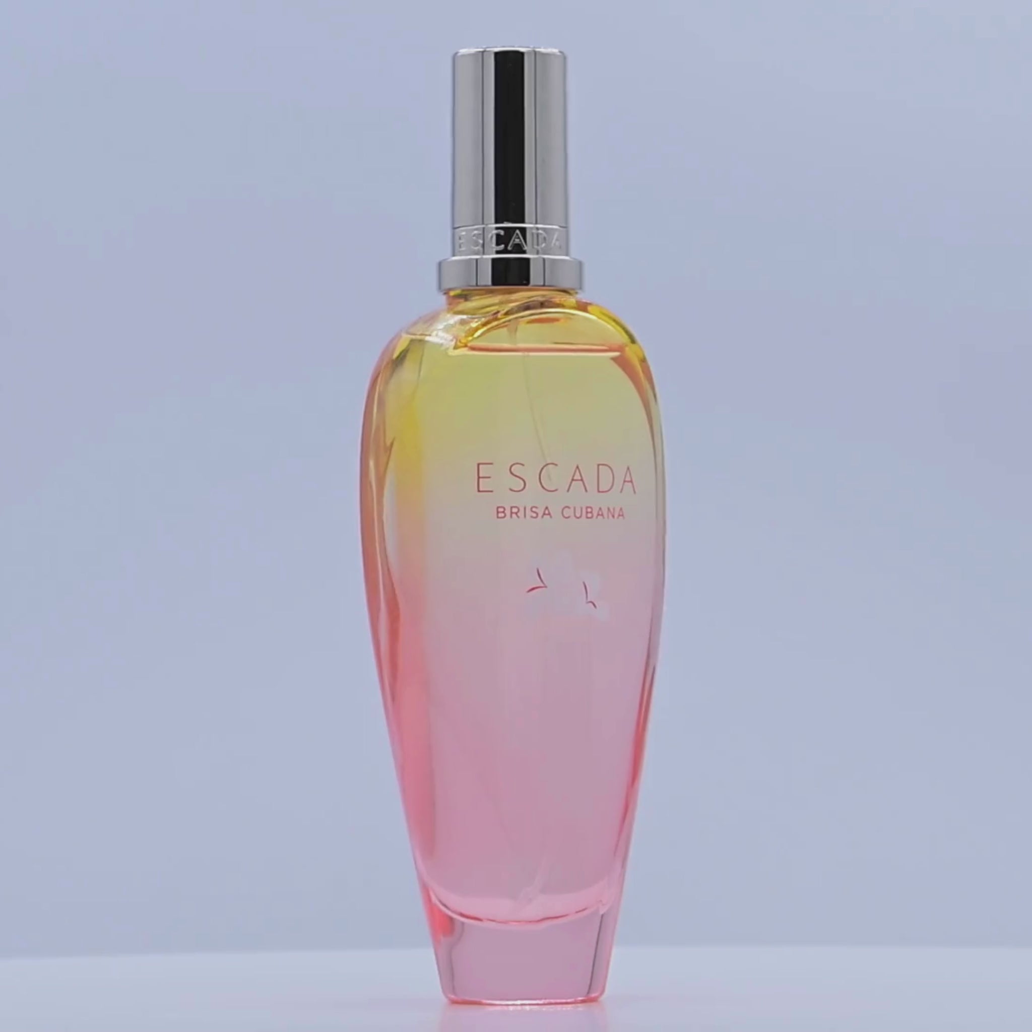 Escada Brisa Cubana perfume bottle rotating on a white podium