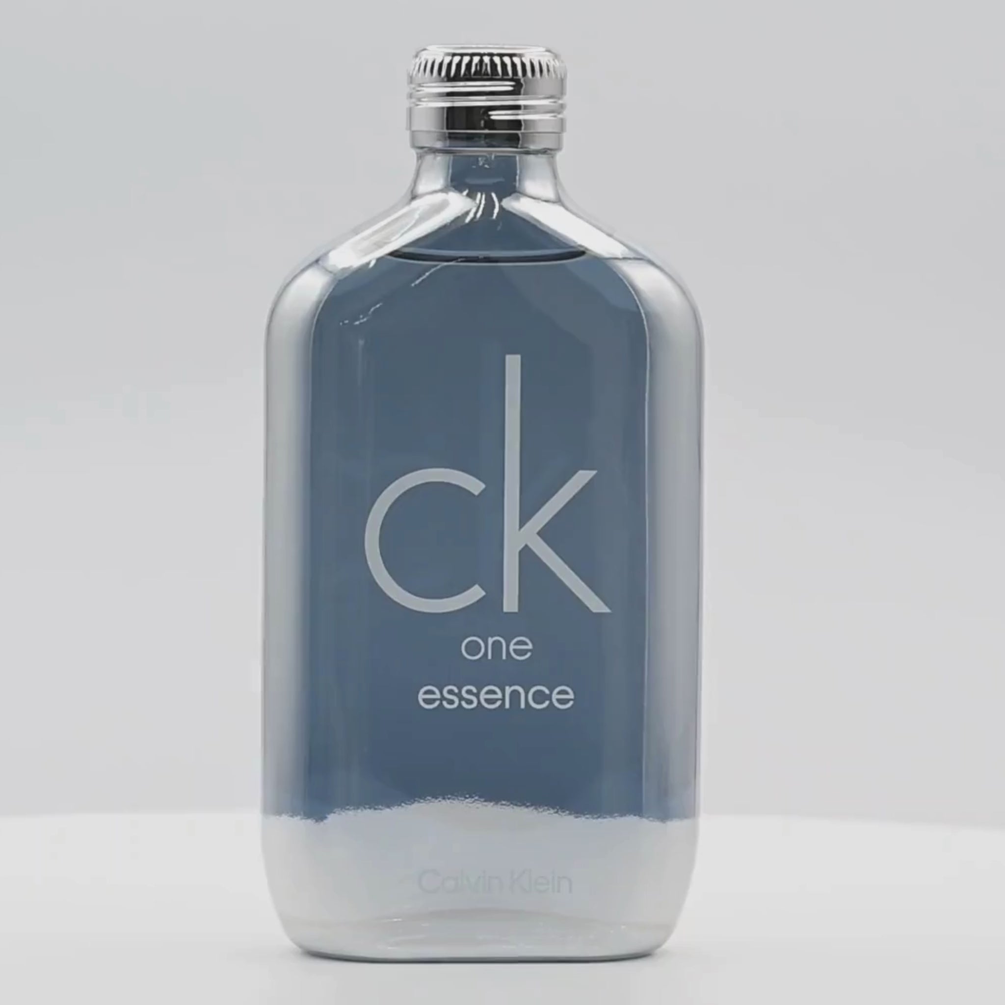 A bottle of Calvin Klein perfume rotating on a white podium
