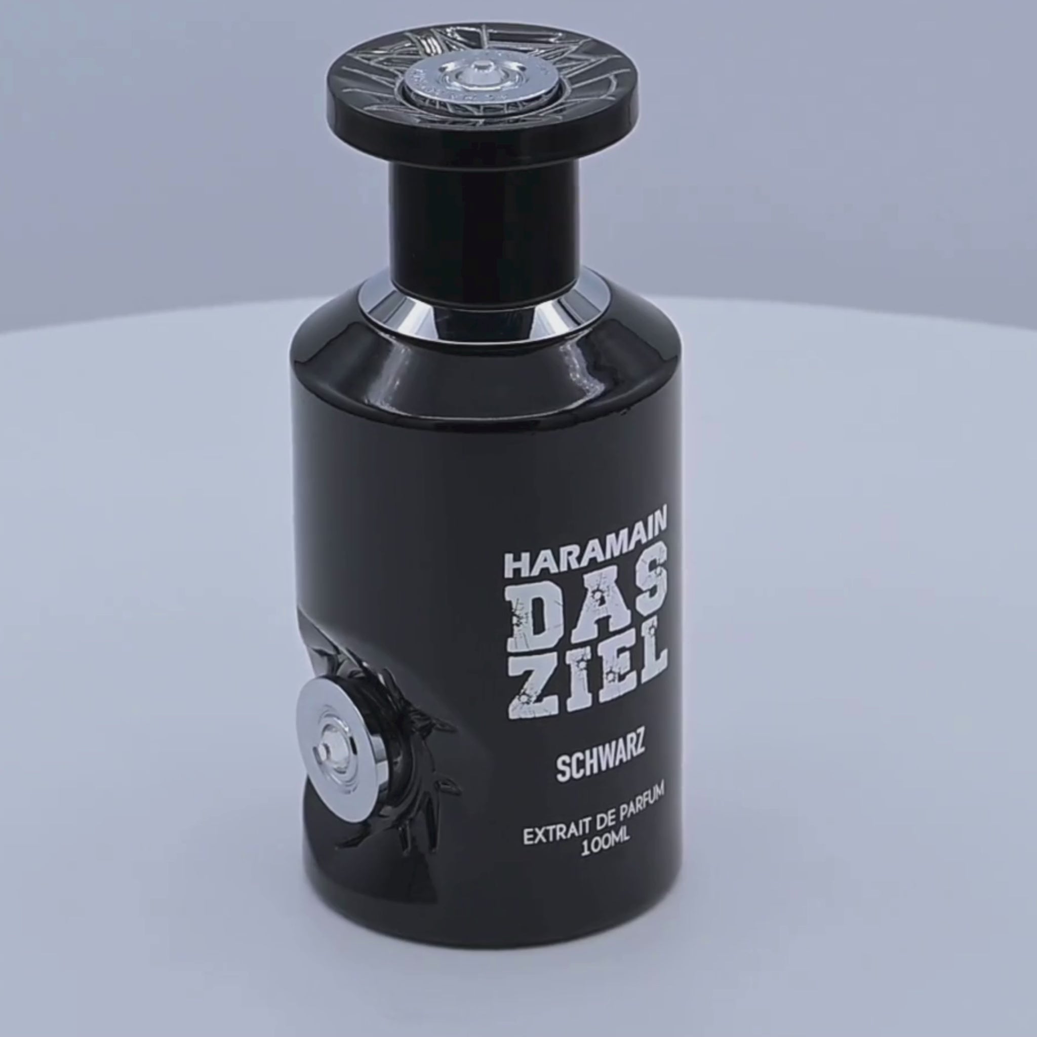 Haramain Das Ziel Schwarz perfume bottle rotating on a white podium