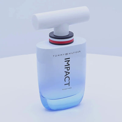 Tommy Hilfiger Impact Together perfume bottle rotating on a white podium