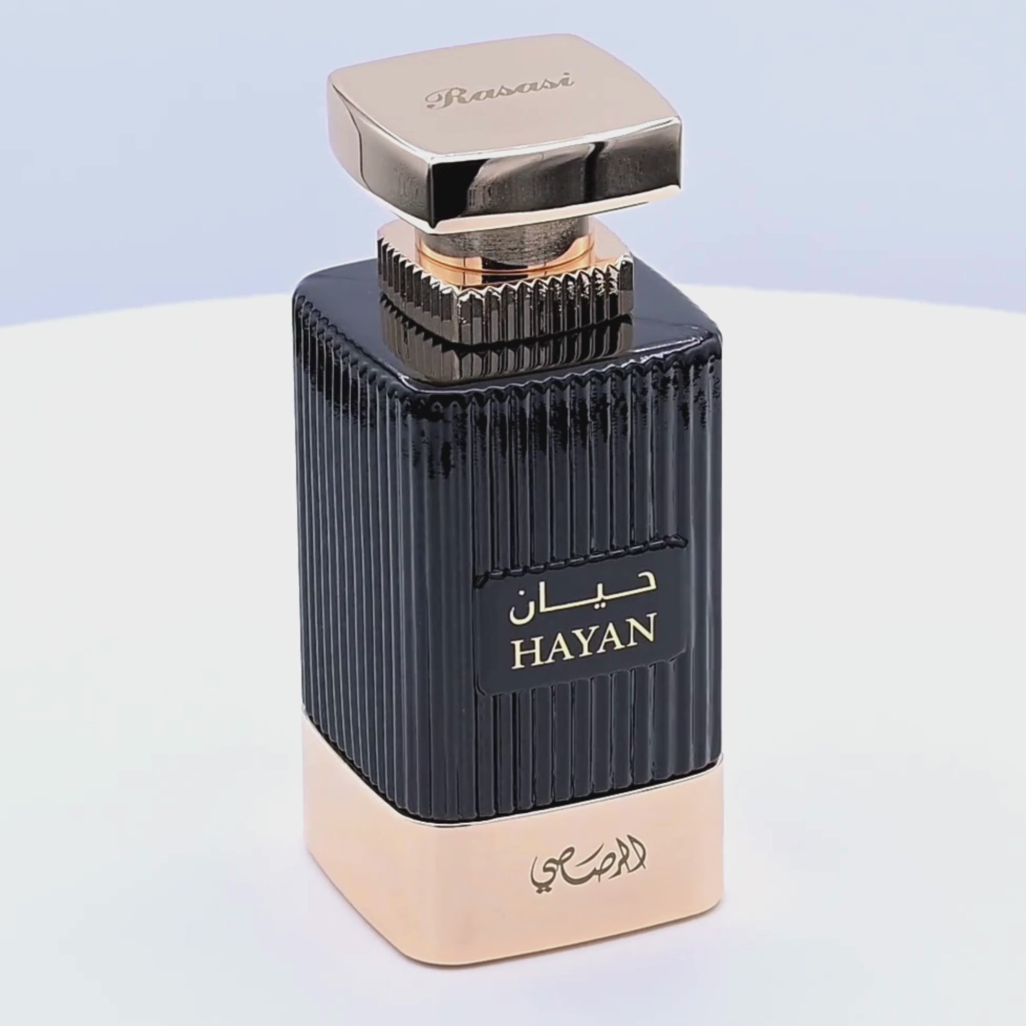Perfume bottle with black and gold design rotating on a white podium