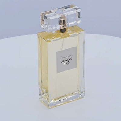 Elizabeth Arden Always Red perfume bottle rotating on a white podium