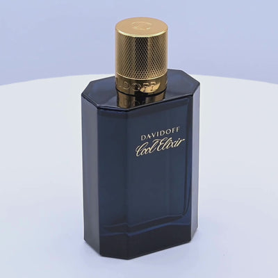 Davidoff Cool Elixir perfume bottle with gold cap rotating on a white podium