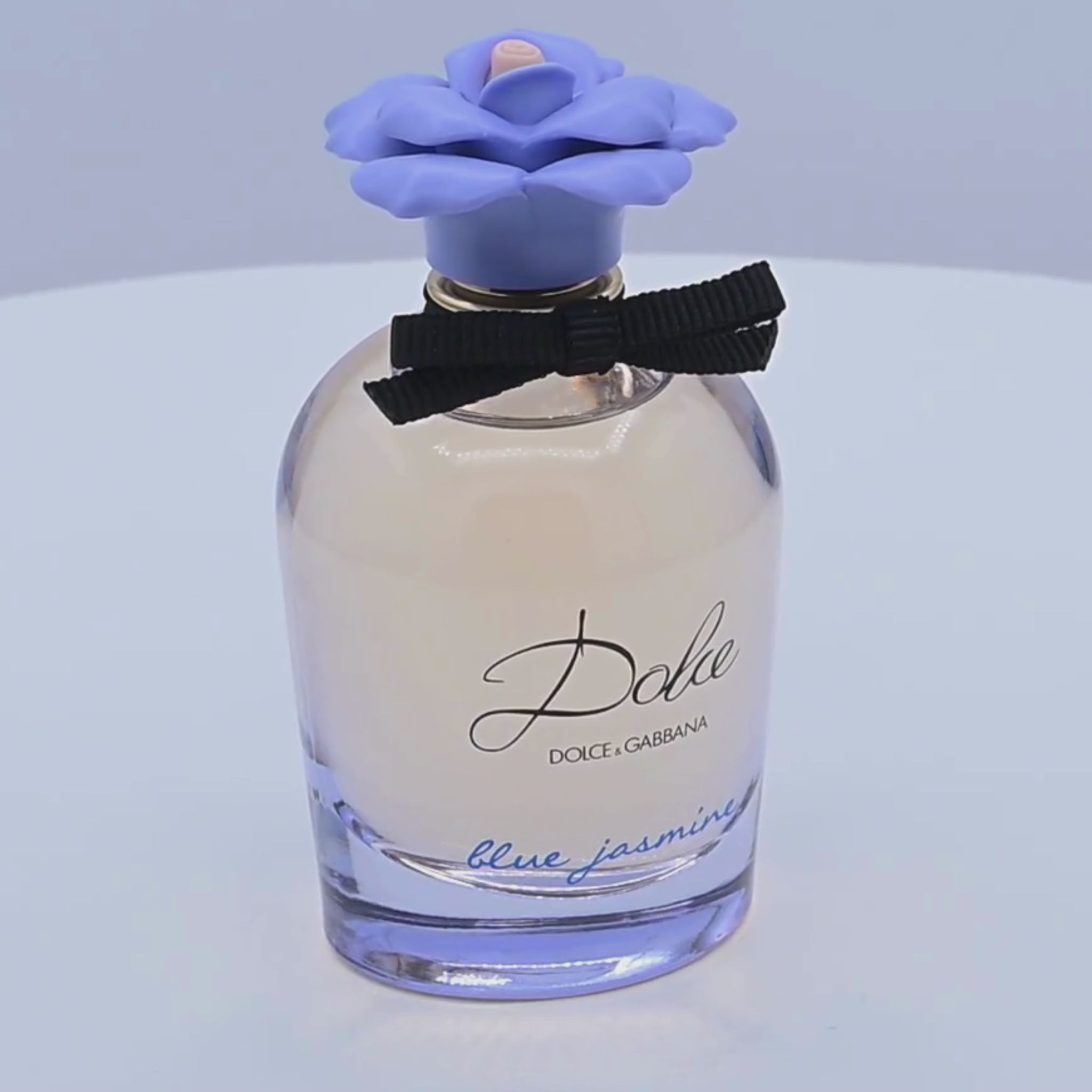 Dolce & Gabbana perfume bottle rotating on a white podium