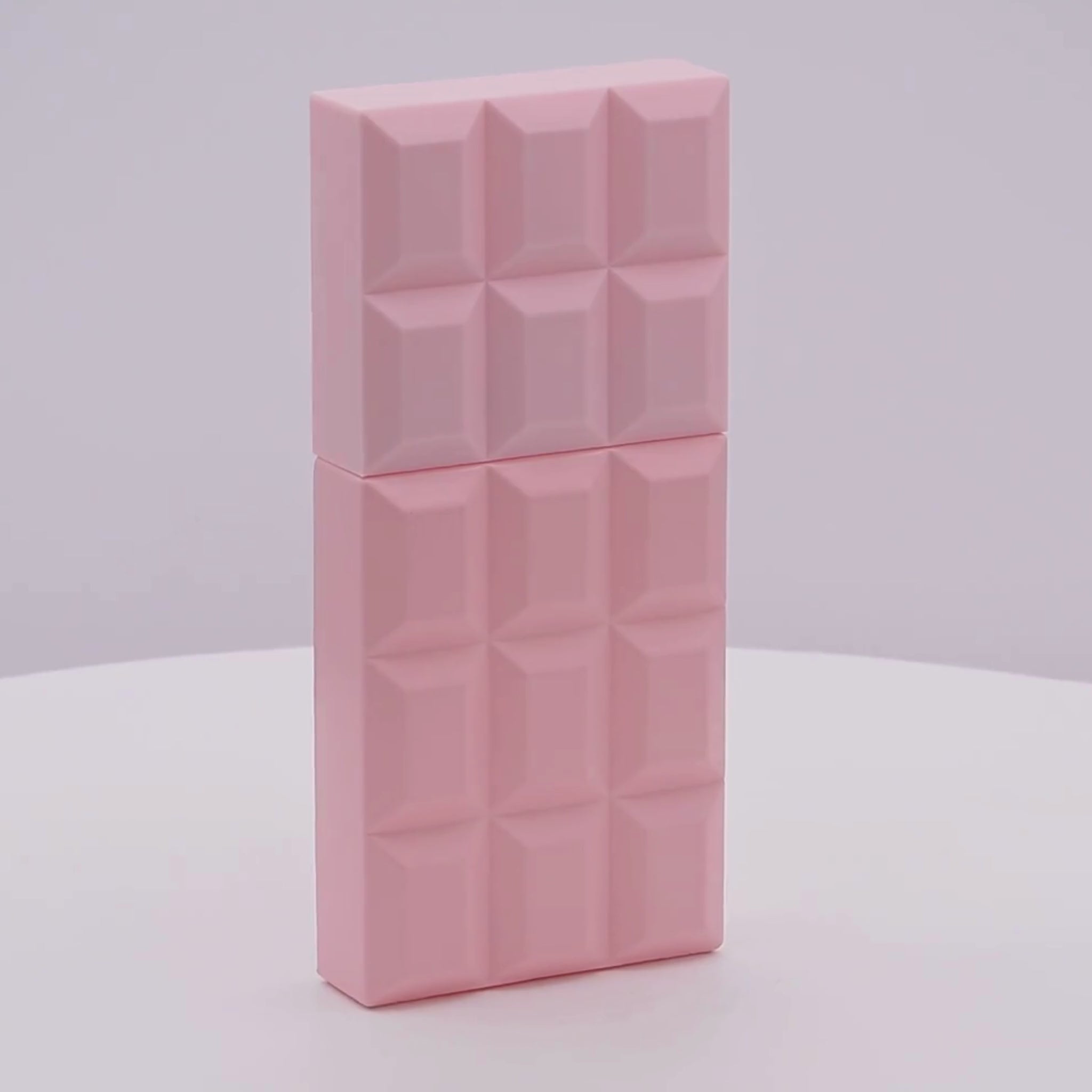 Pink perfume bottle with geometric pattern rotating on a white podium
