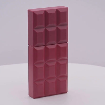 Red perfume bottle with geometric design rotating on a white podium