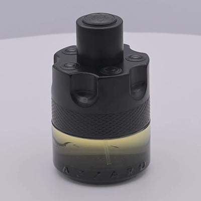 Azzaro The Most Wanted perfume bottle rotating on a white podium